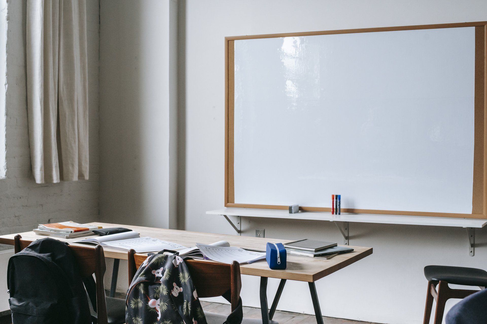 A classroom with a whiteboard and a table and chairs.