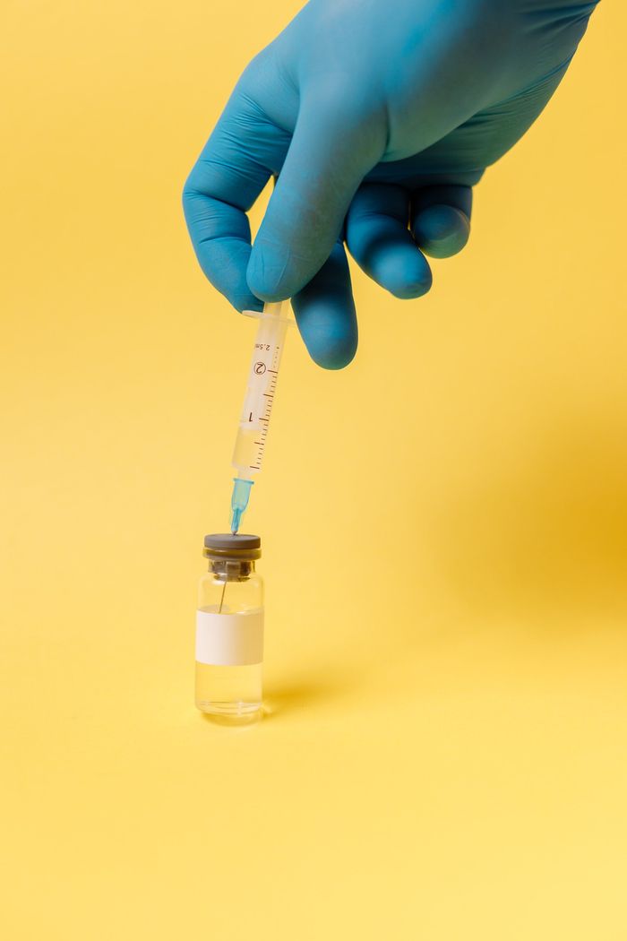 Gloved Hand Drawing Liquid Into a Syringe Above a Small Vial in Boise, ID