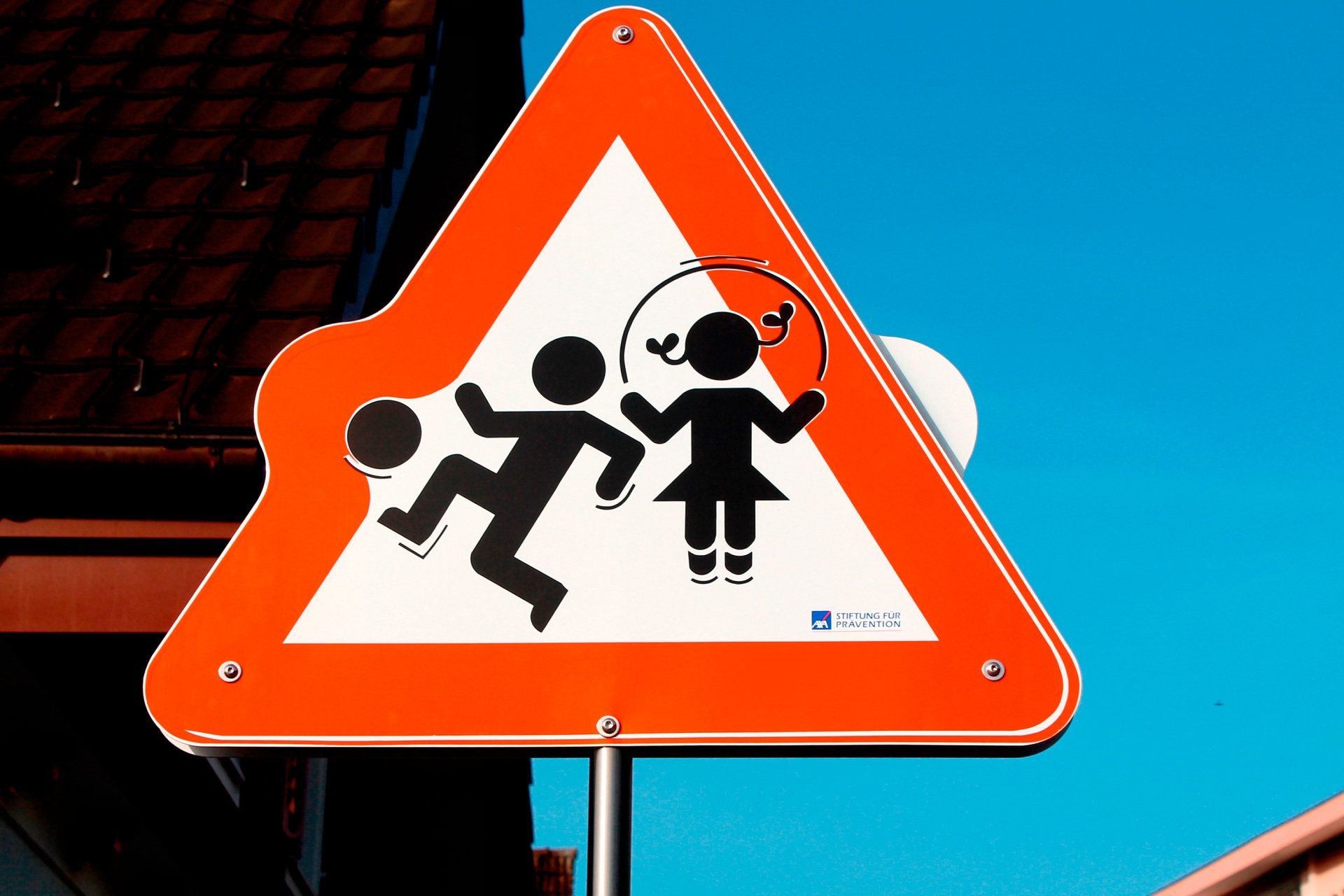 An orange and white sign shows a boy and a girl jumping a jump rope