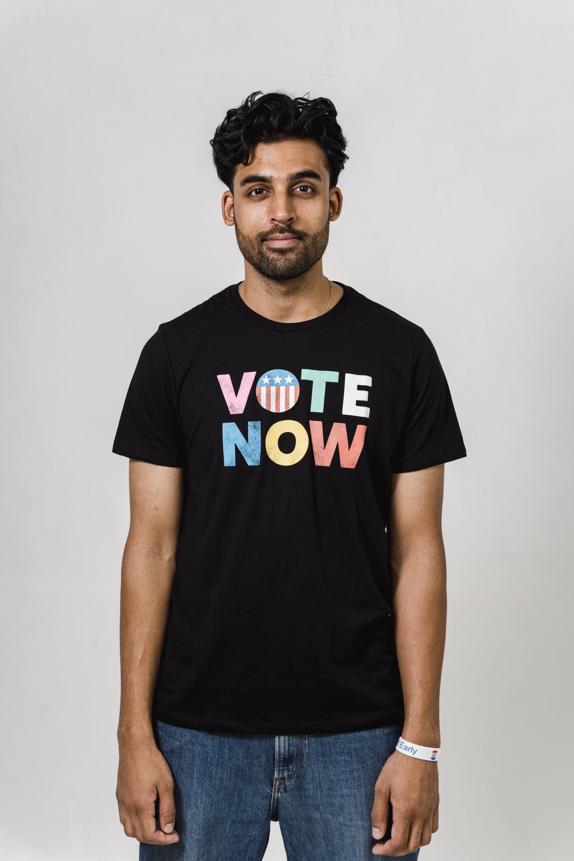 Uma pessoa de frente vestindo uma camiseta preta com a inscrição 