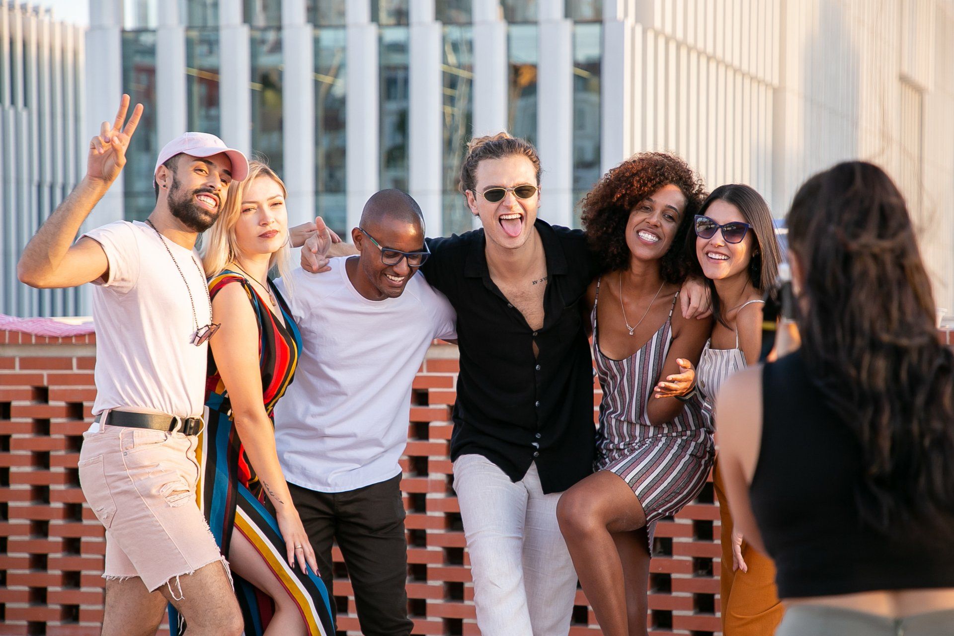 a woman is taking a picture of a group of people posing for a picture .