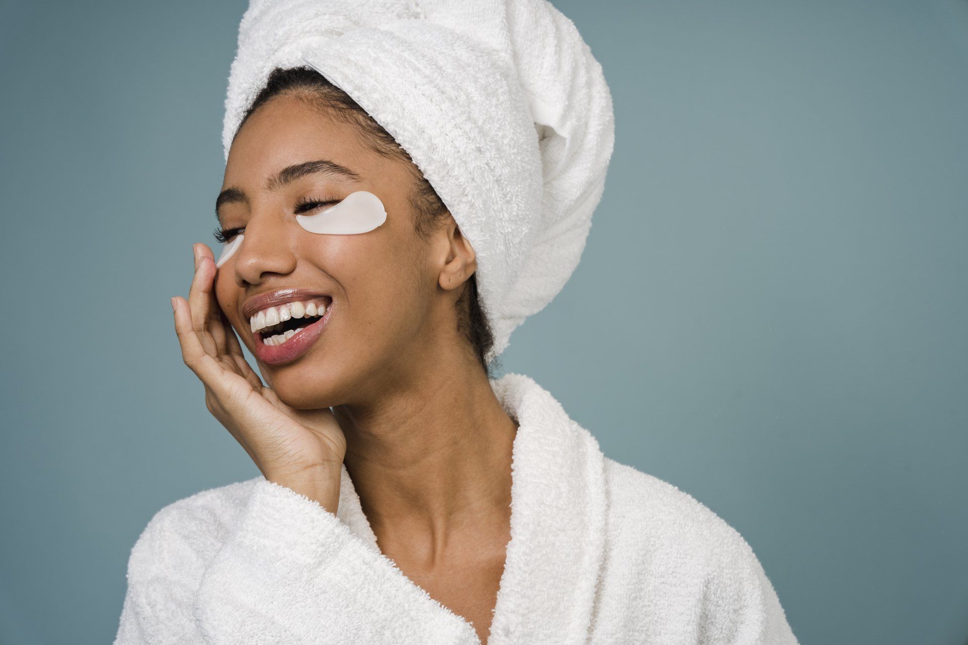 A woman with a towel wrapped around her head and eye patches on her face.