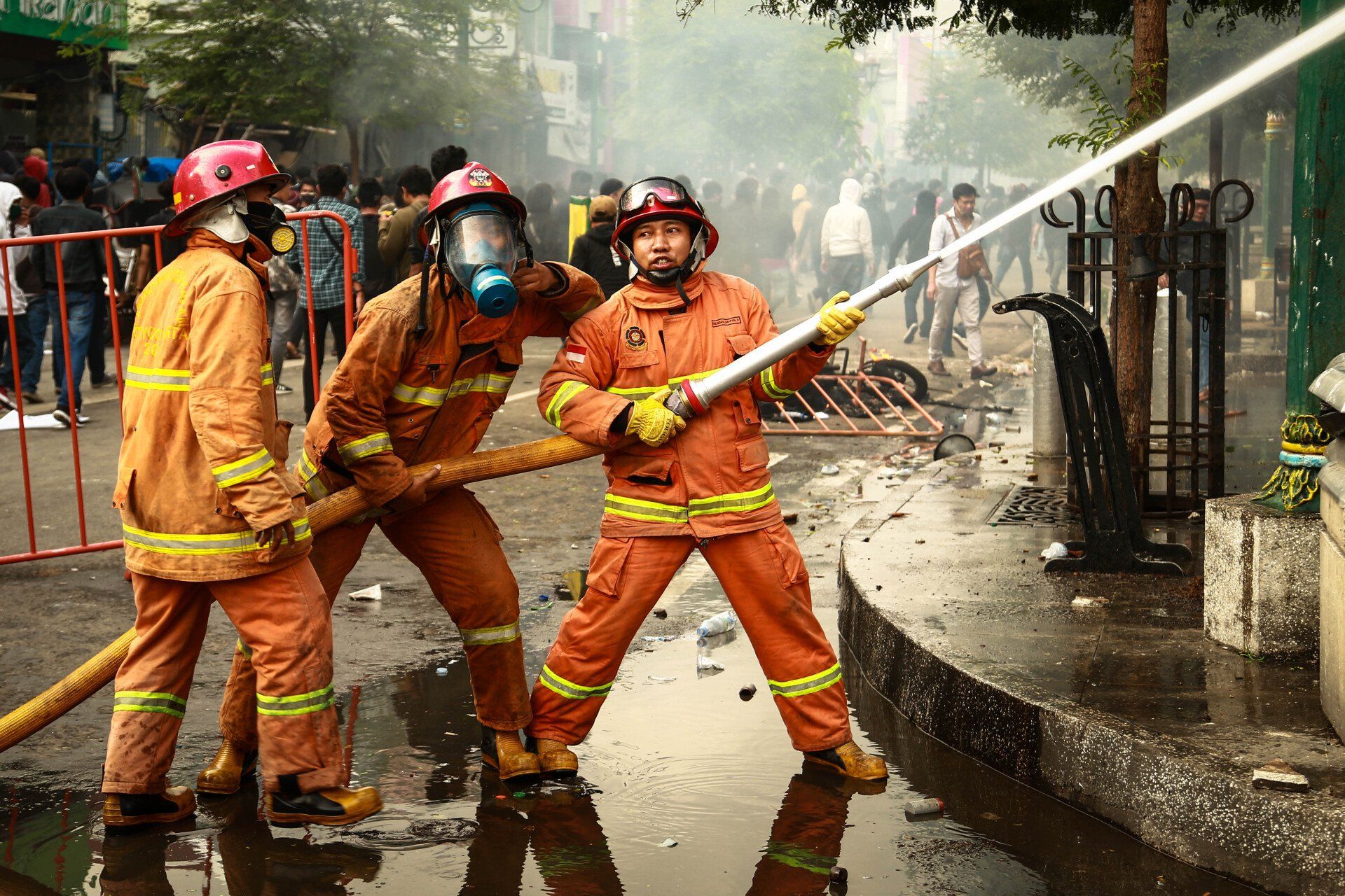 A group of firefighters are spraying water on a fire