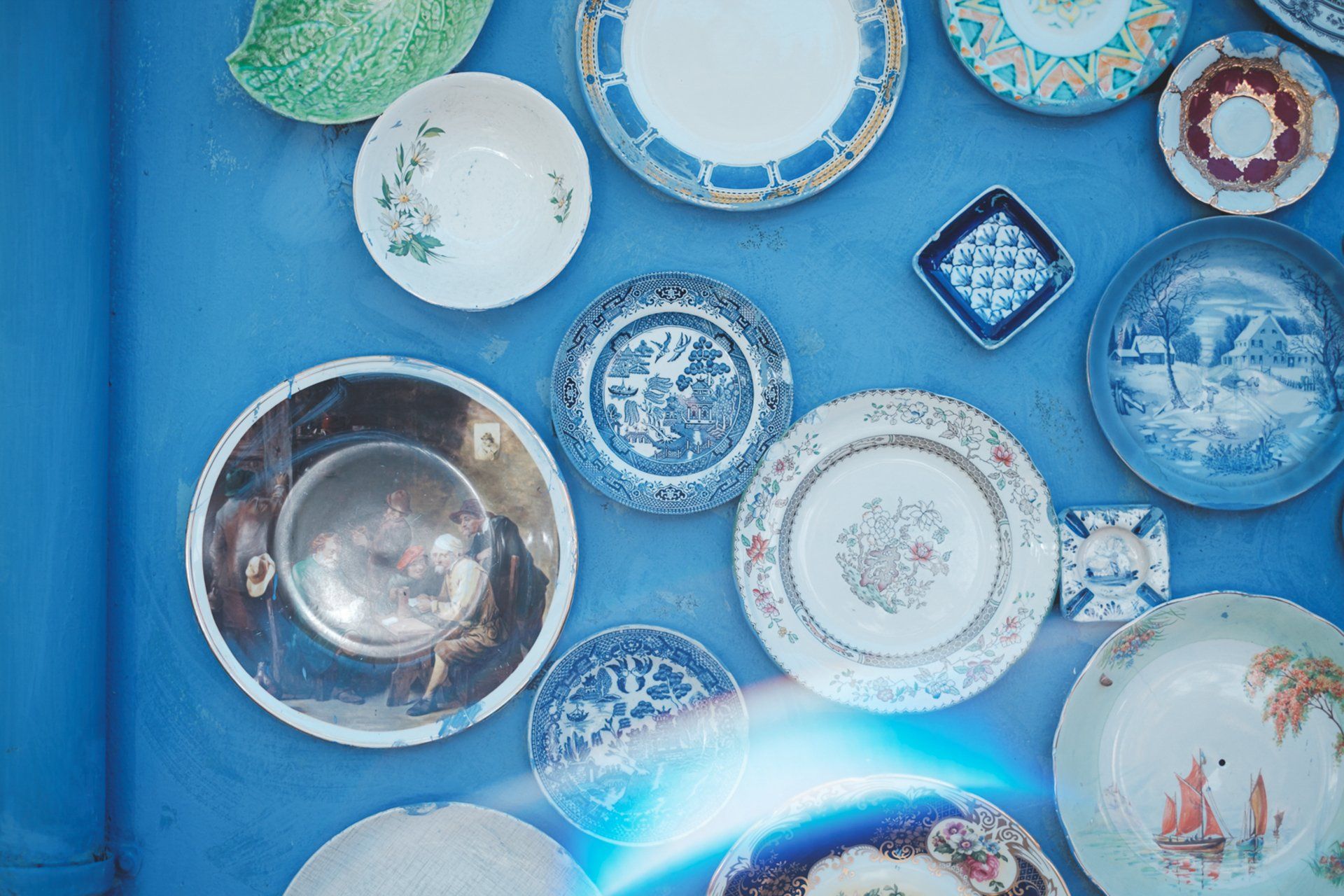 Vintage dining plates laid out on a blue background