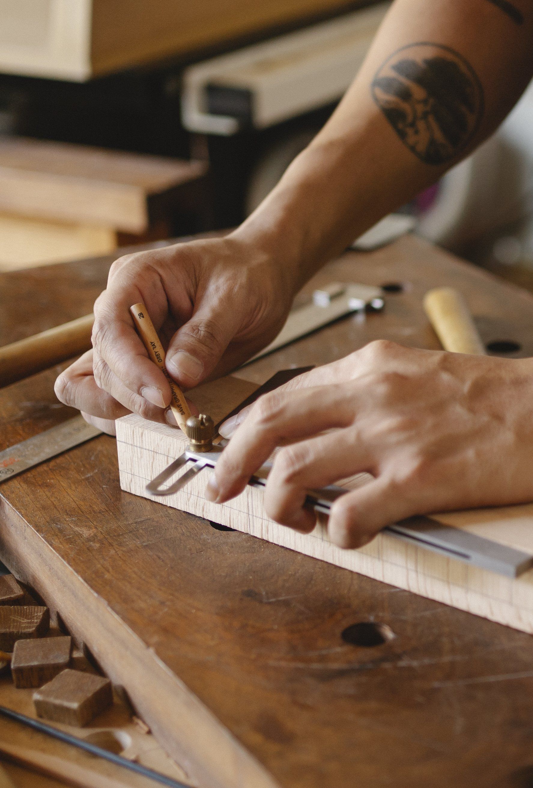 A person is measuring a piece of wood with a ruler.