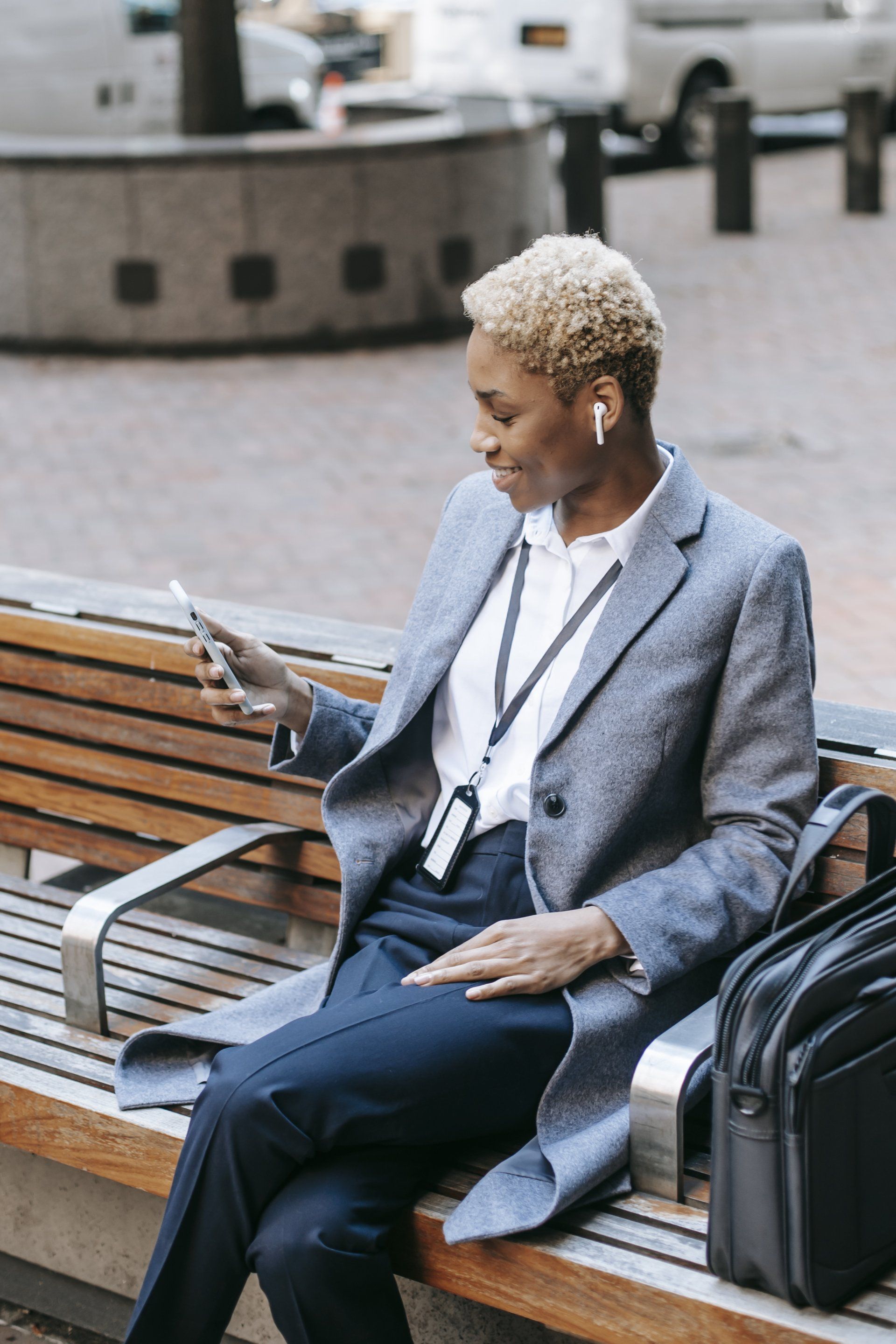 A woman is sitting on a bench looking at her phone.