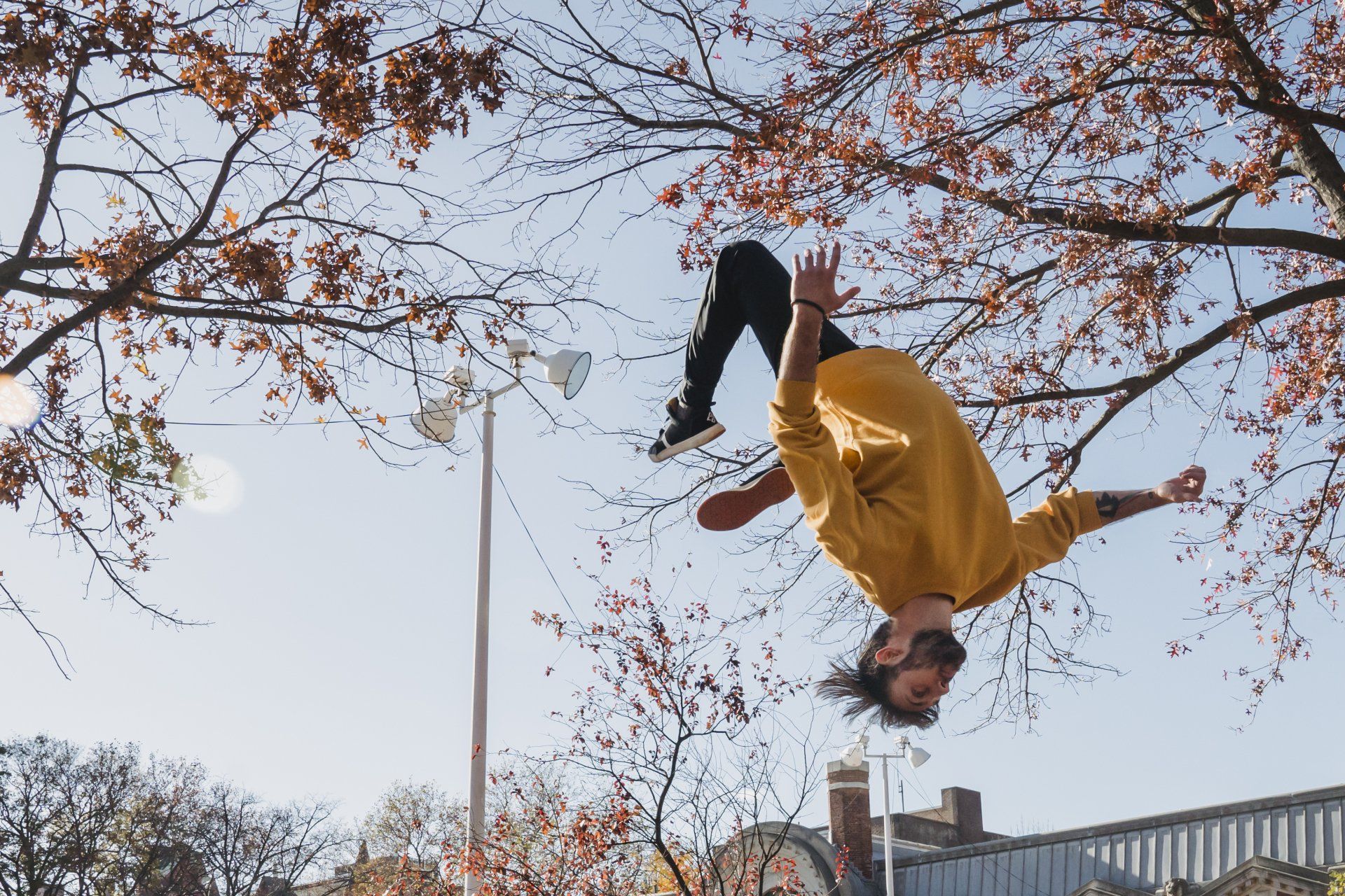 man in yellow shirt upside down flipping