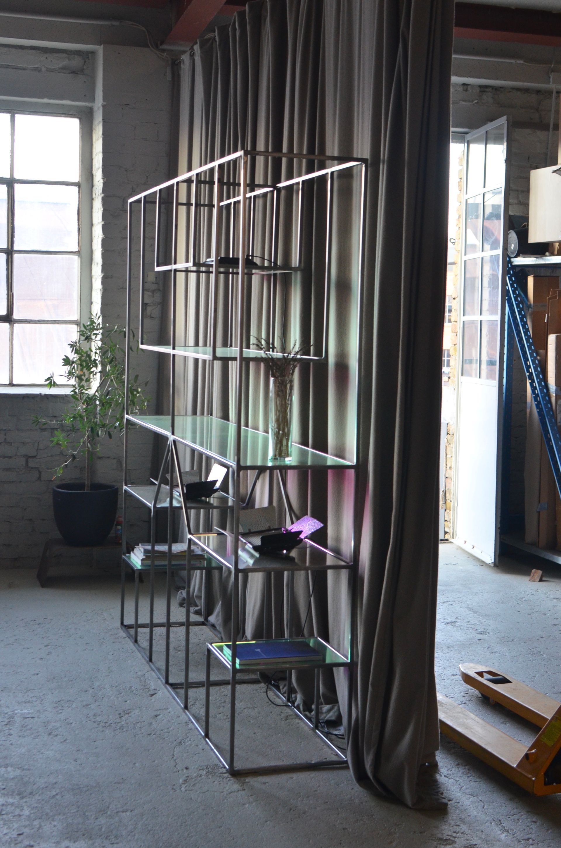 A room with shelves and a curtain between them