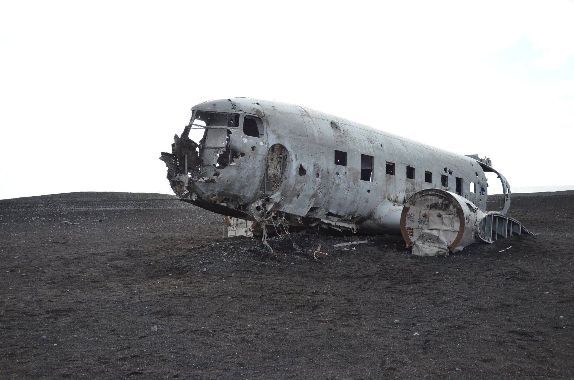 Resilience A wrecked airplane is sitting on top of a dirt field.
