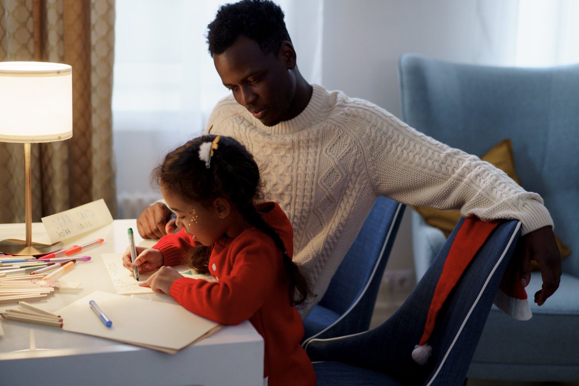 A man is helping a little girl with her homework.