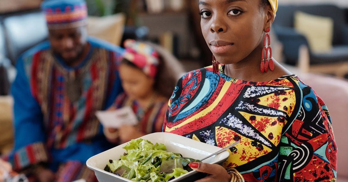 A woman is holding a bowl of salad in front of a family.