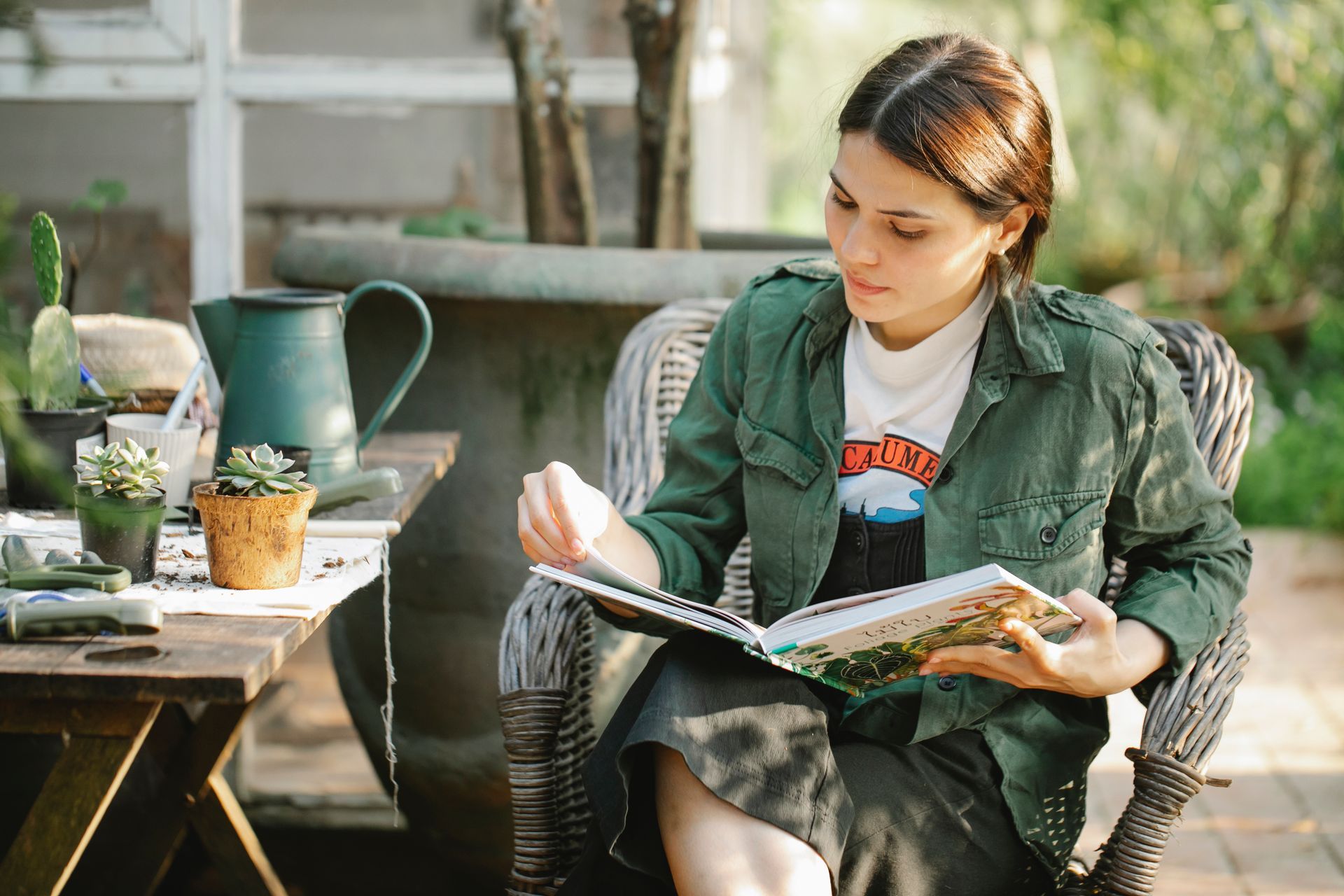 A woman is sitting in a chair reading a book.