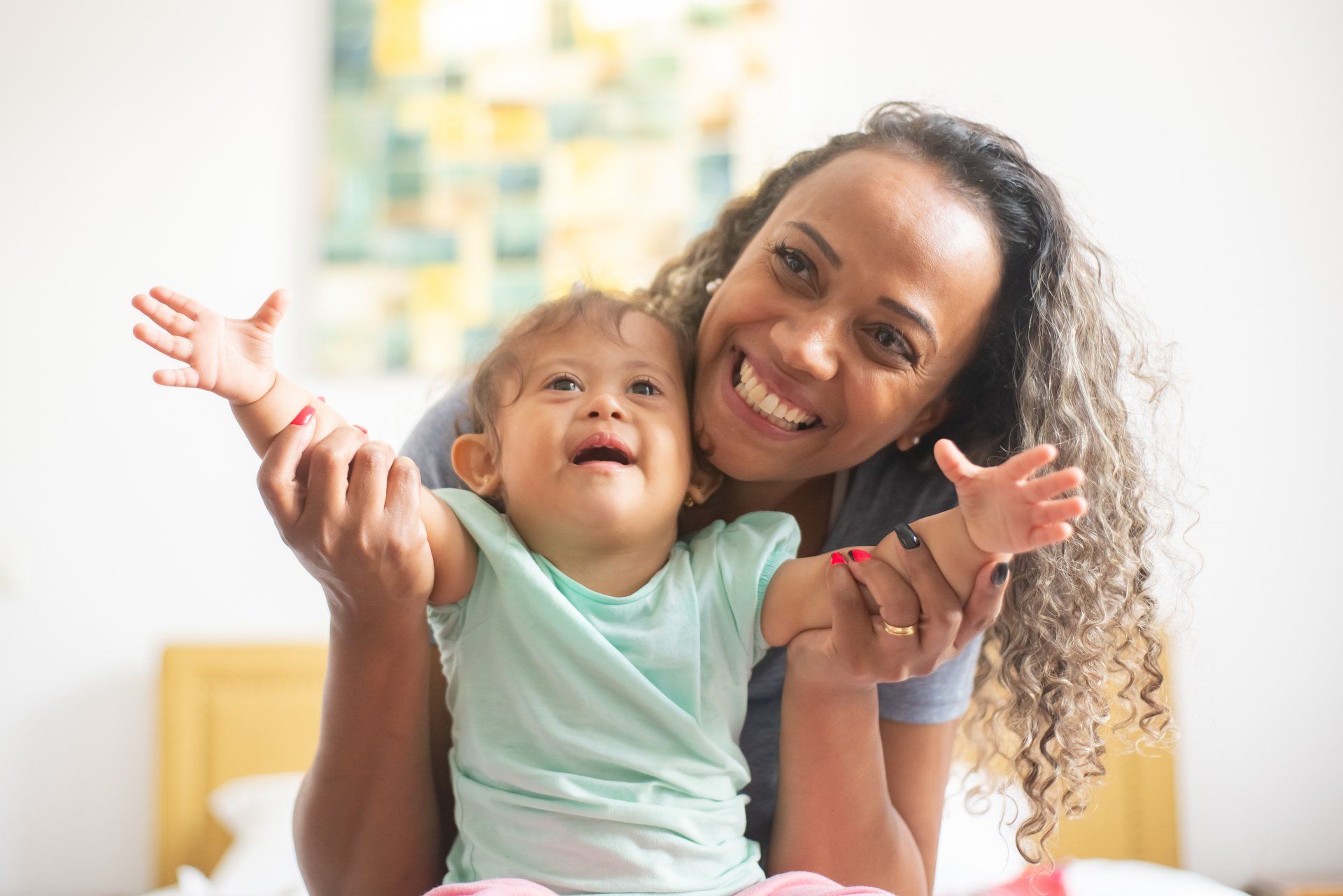 A woman is holding a baby in her arms on a bed.