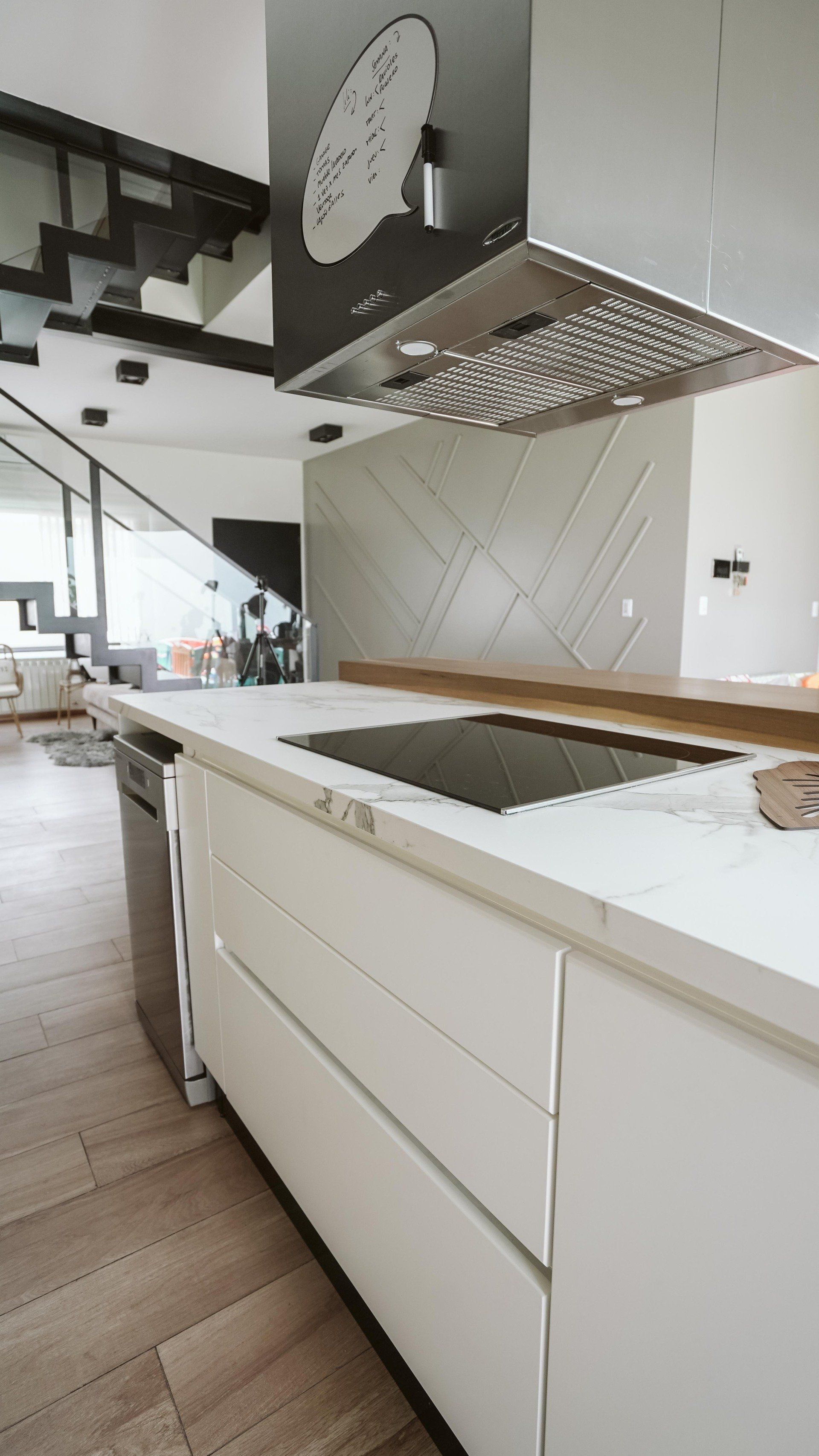 A kitchen with white cabinets and a stove top oven.