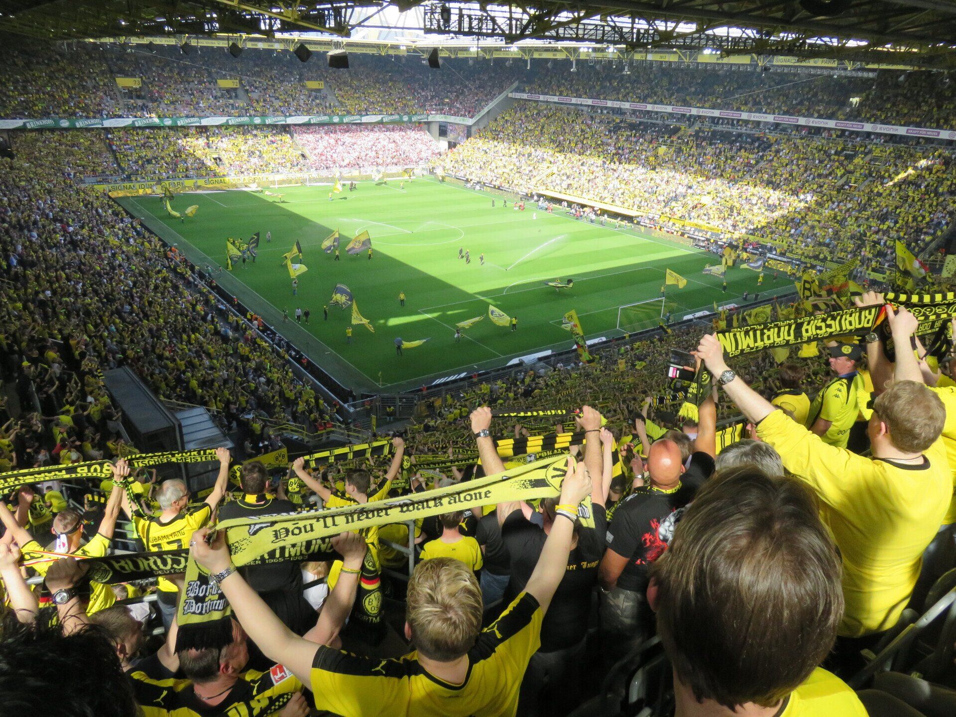 A crowd of people are watching a soccer game in a stadium
