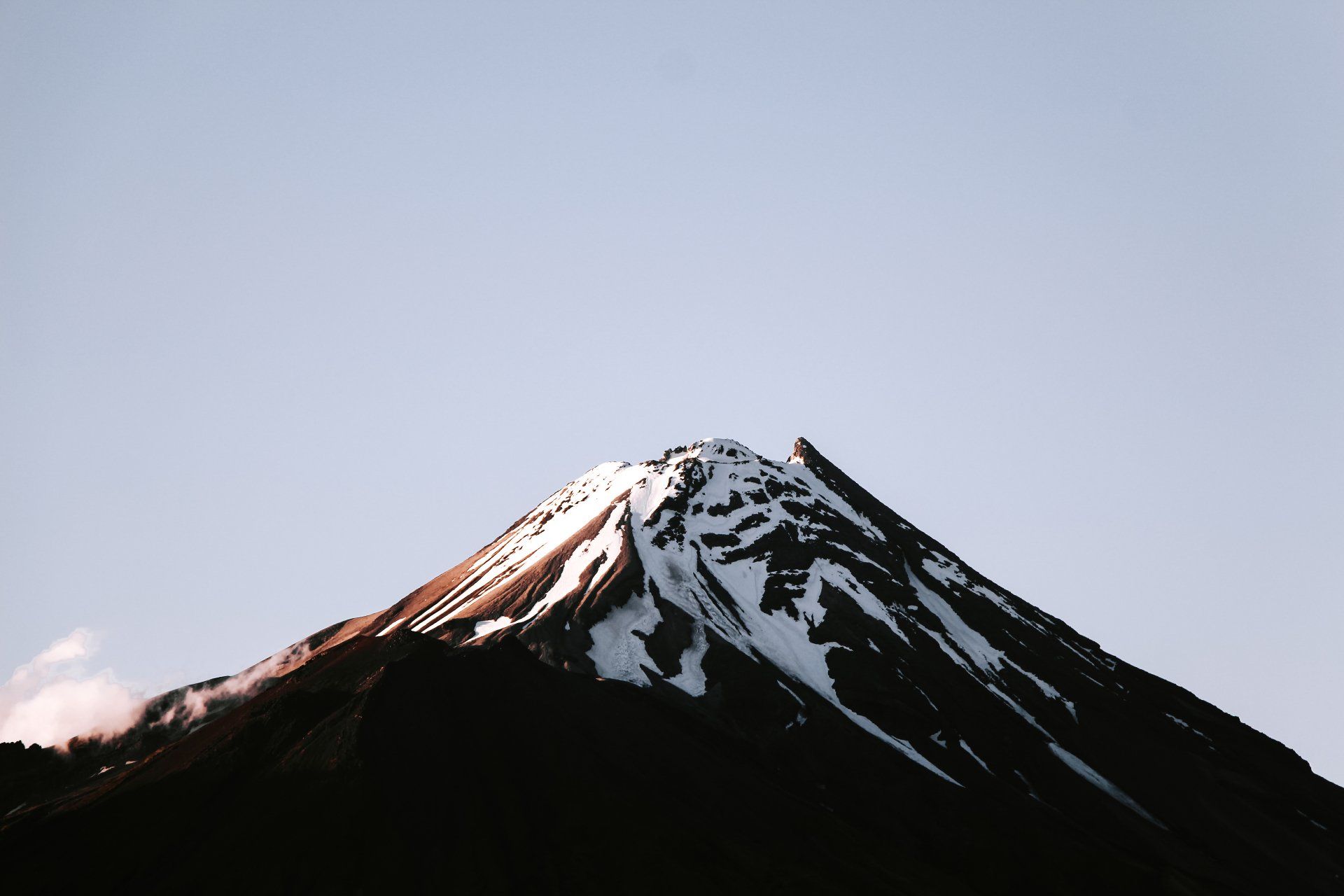 A mountain covered in snow against a blue sky