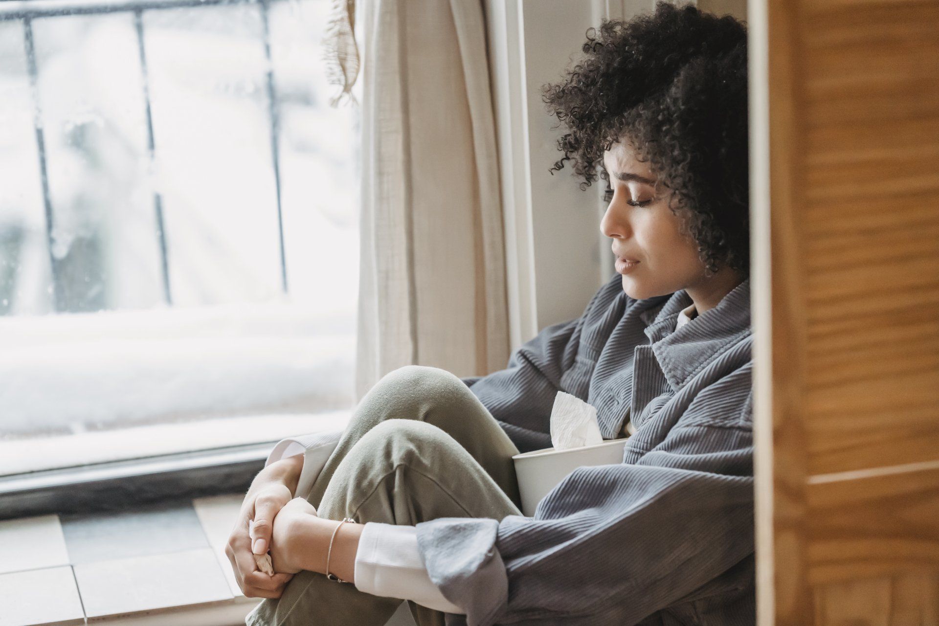 WOMAN SITTING BY A WINDOW