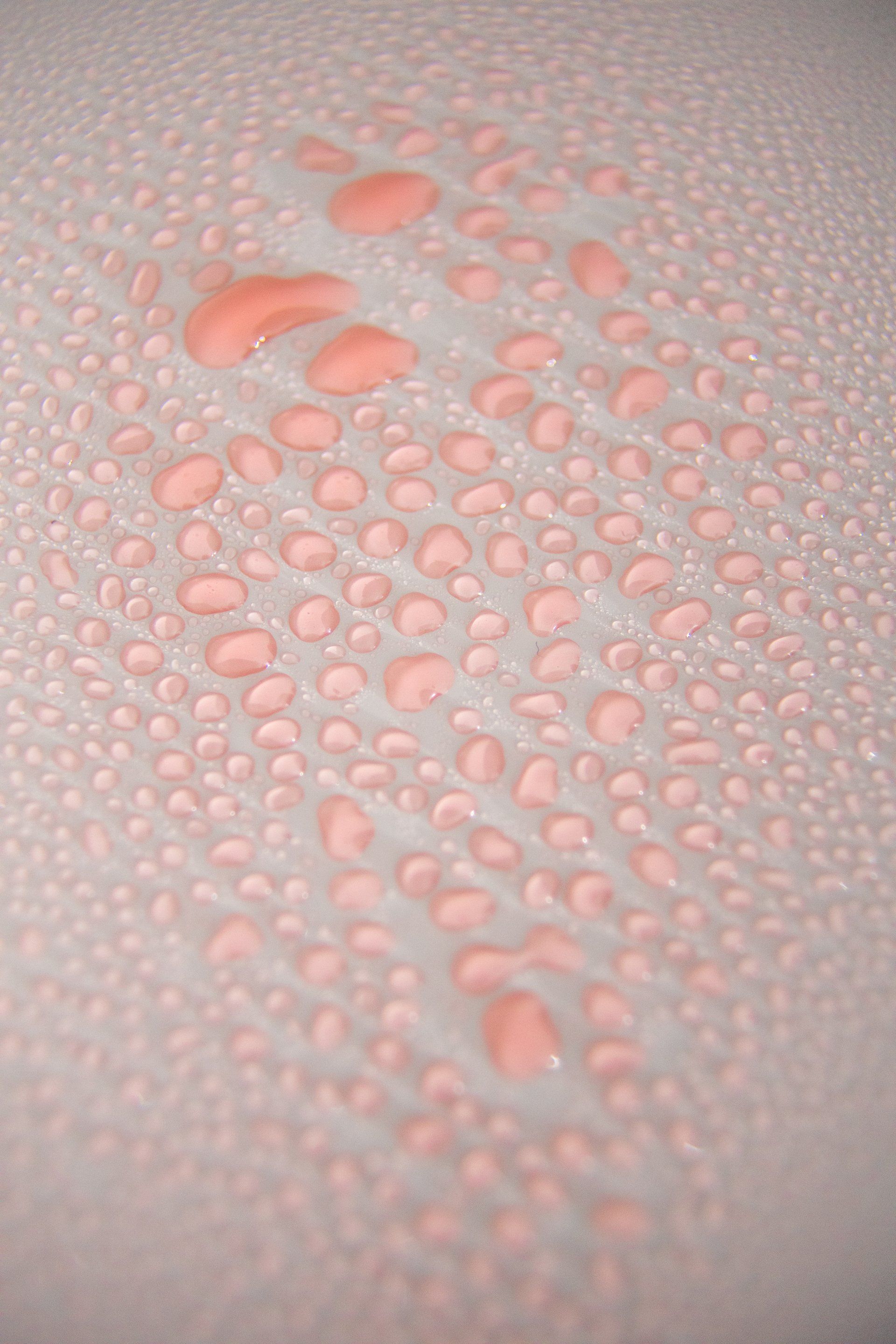 Een close-up van waterdruppels op een wit oppervlak.