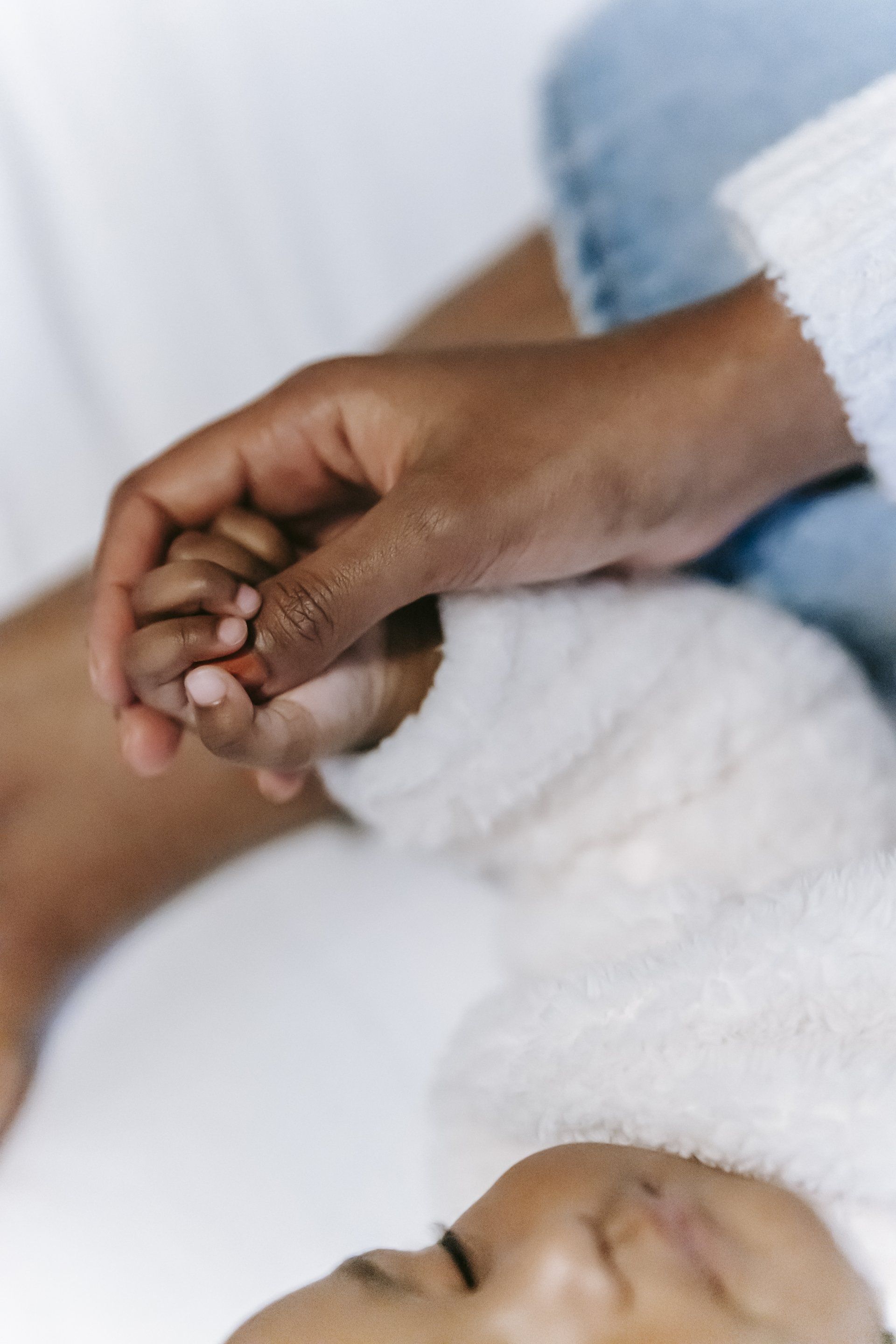 A person and a baby holding hands