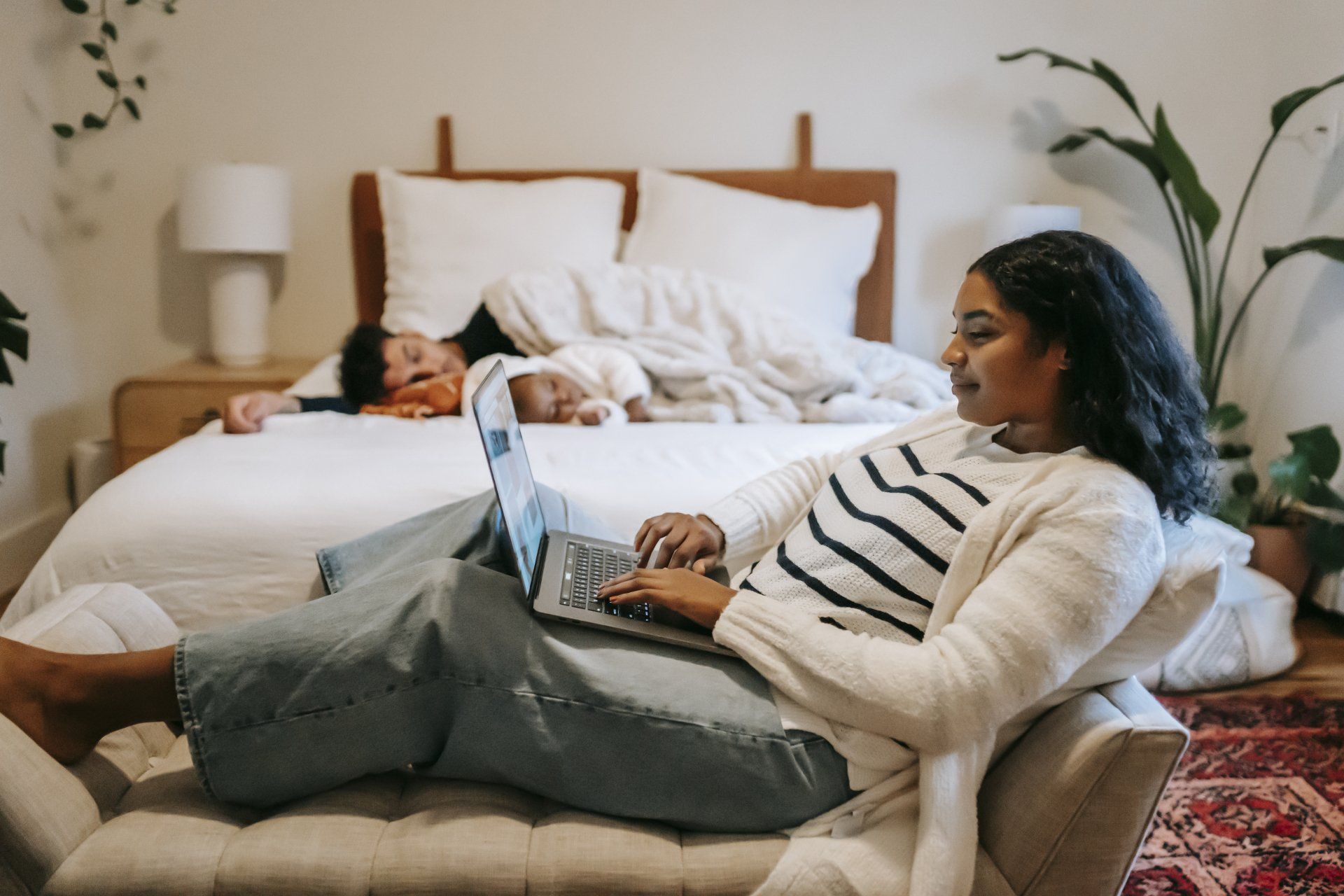 A woman is laying on a couch using a laptop computer.