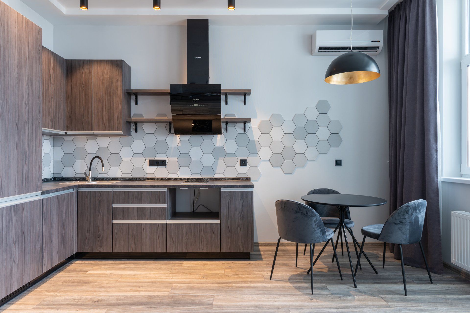 A kitchen with wooden cabinets , a table and chairs.