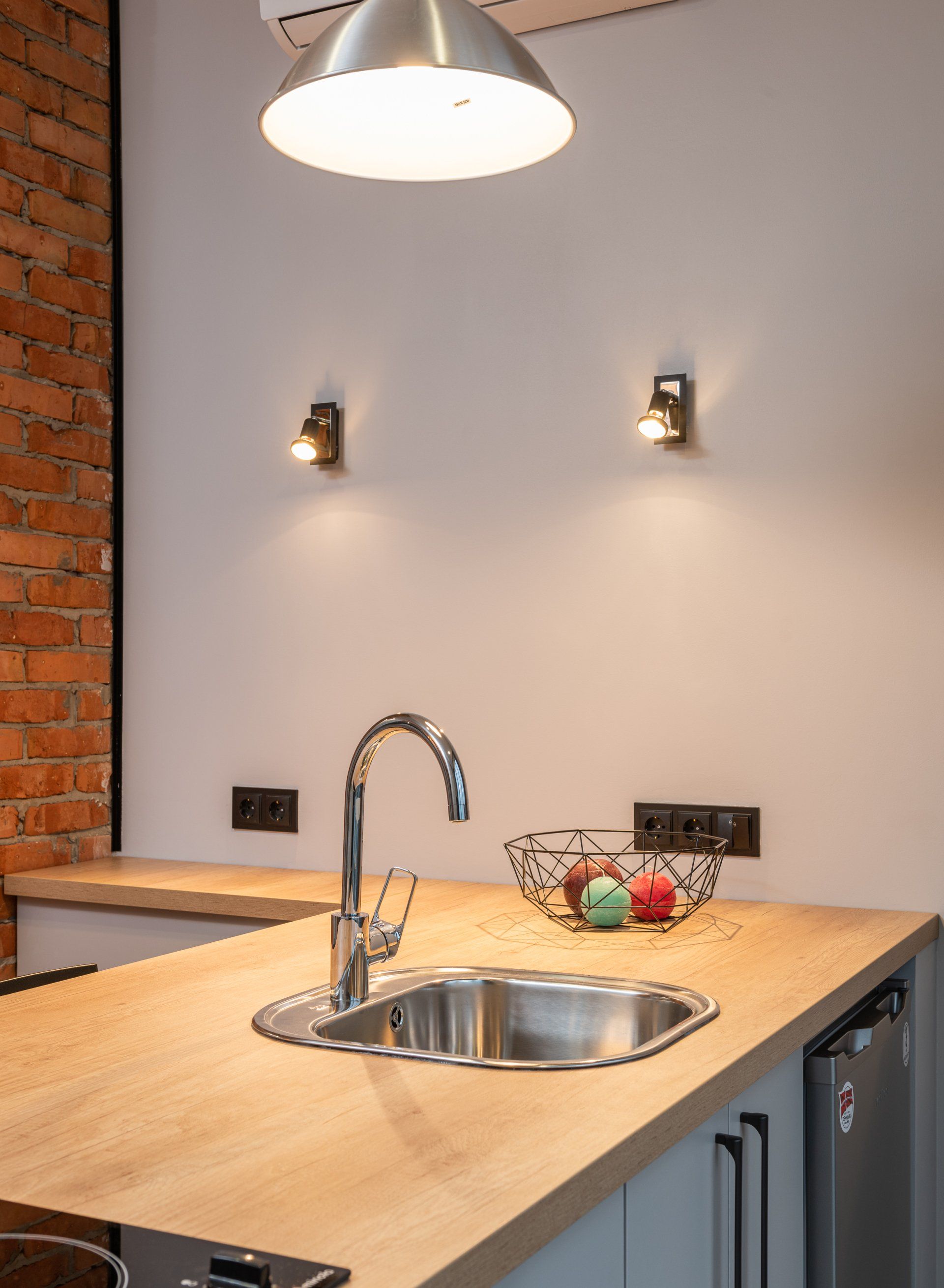 a kitchen with a stainless steel sink and a wooden counter top