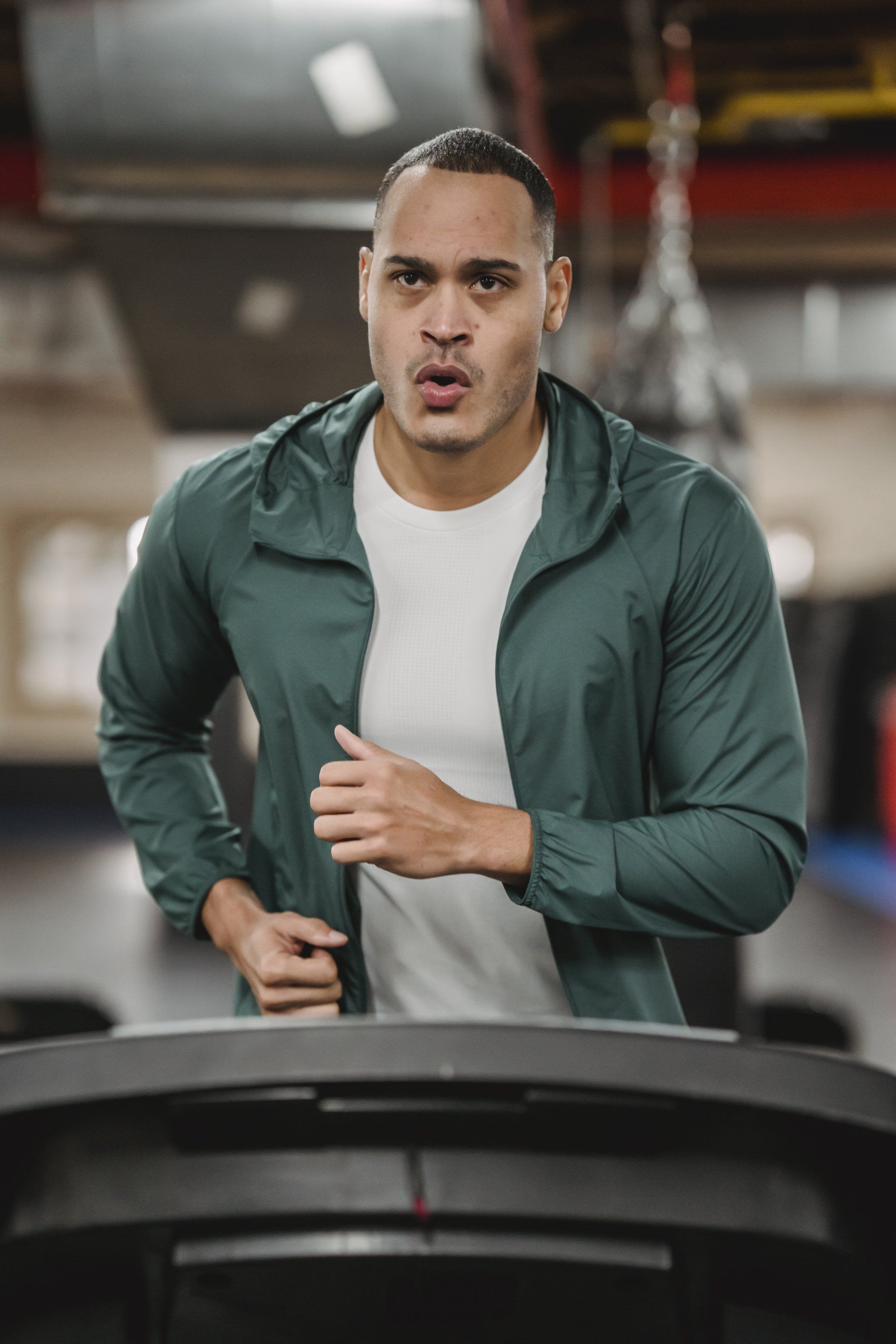 A man is running on a treadmill in a gym.