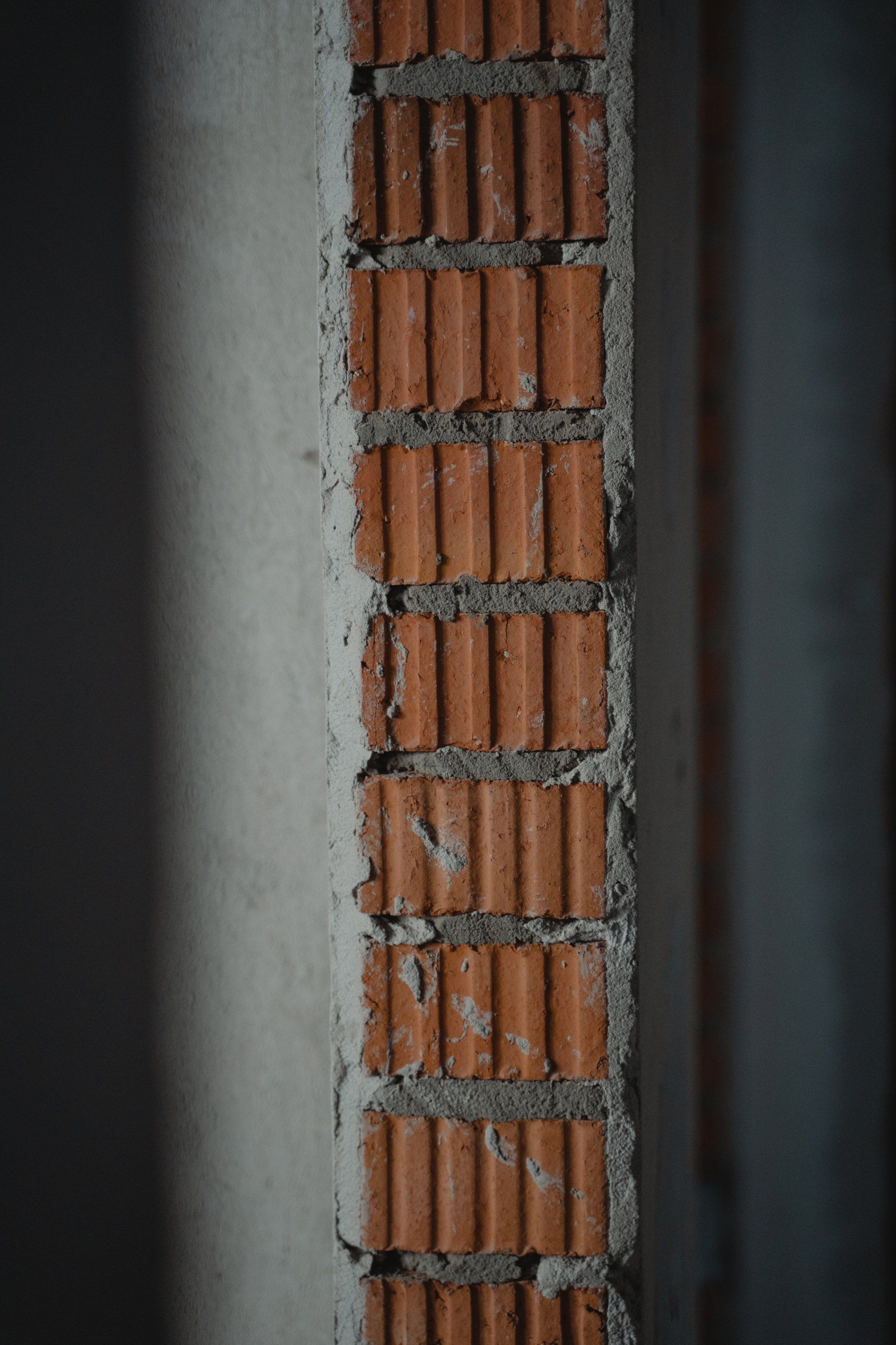A close up of a brick wall with concrete between the bricks.