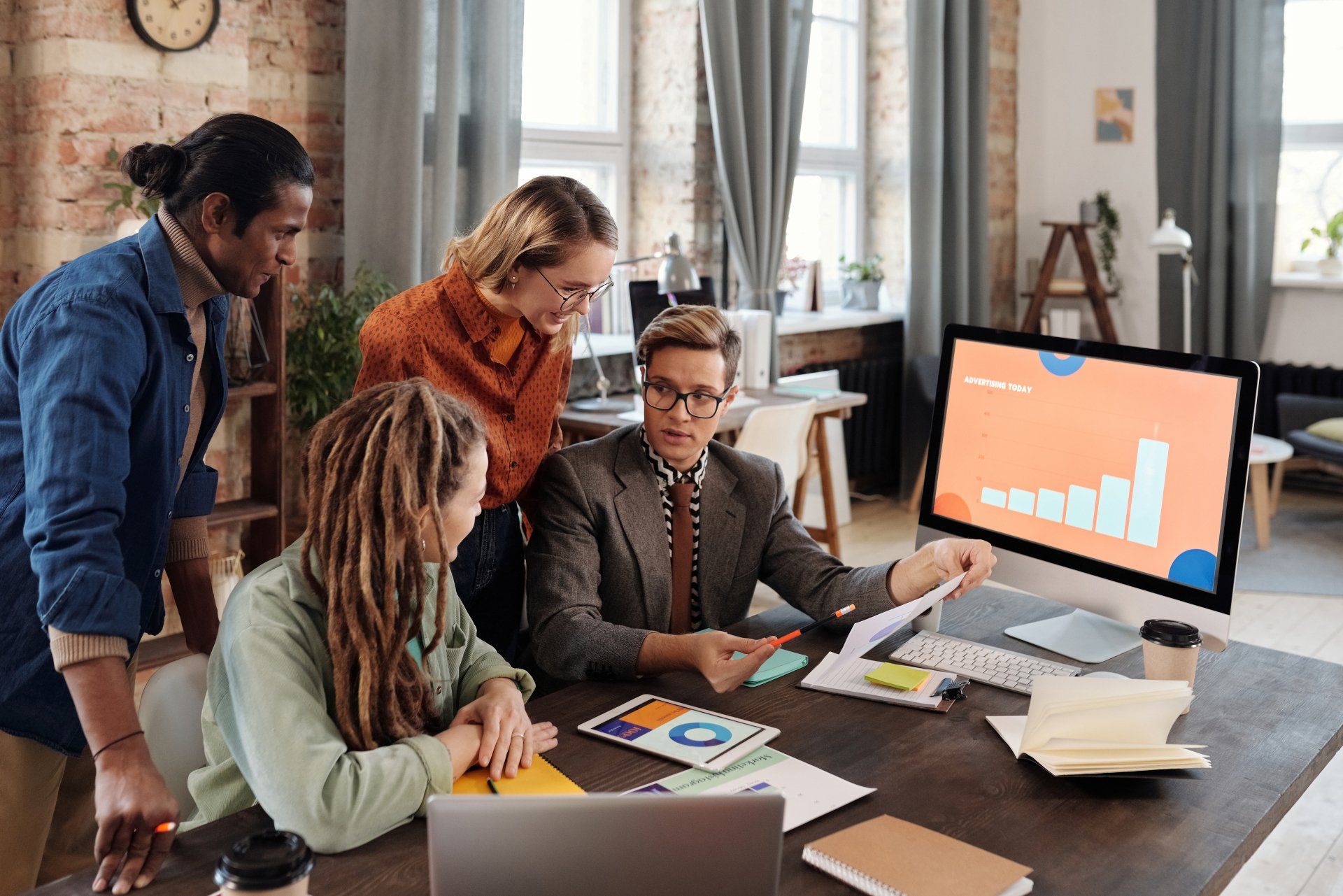 A group of people are sitting around a table looking at a computer screen.