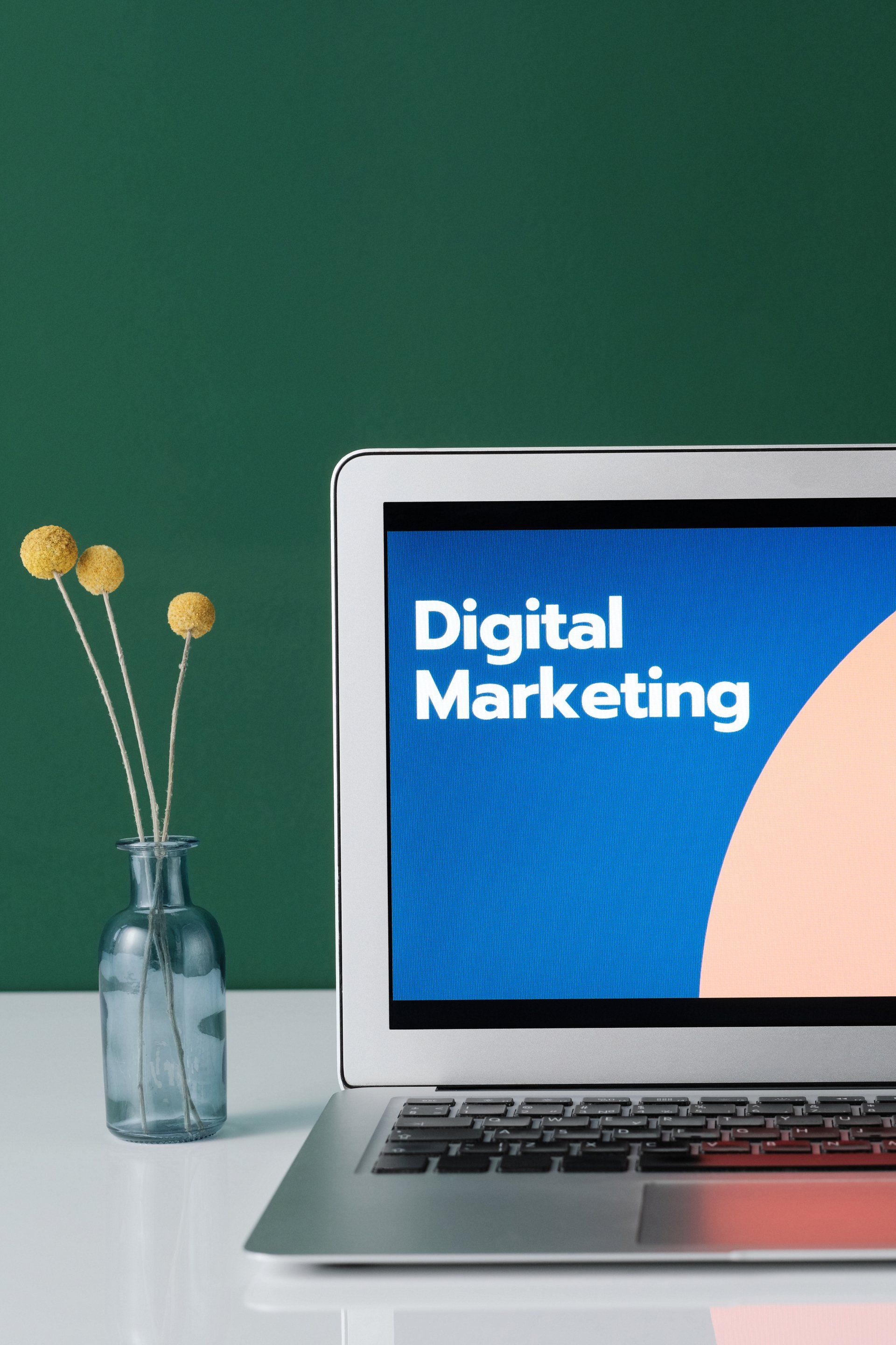 A laptop is open to a screen that says digital marketing
