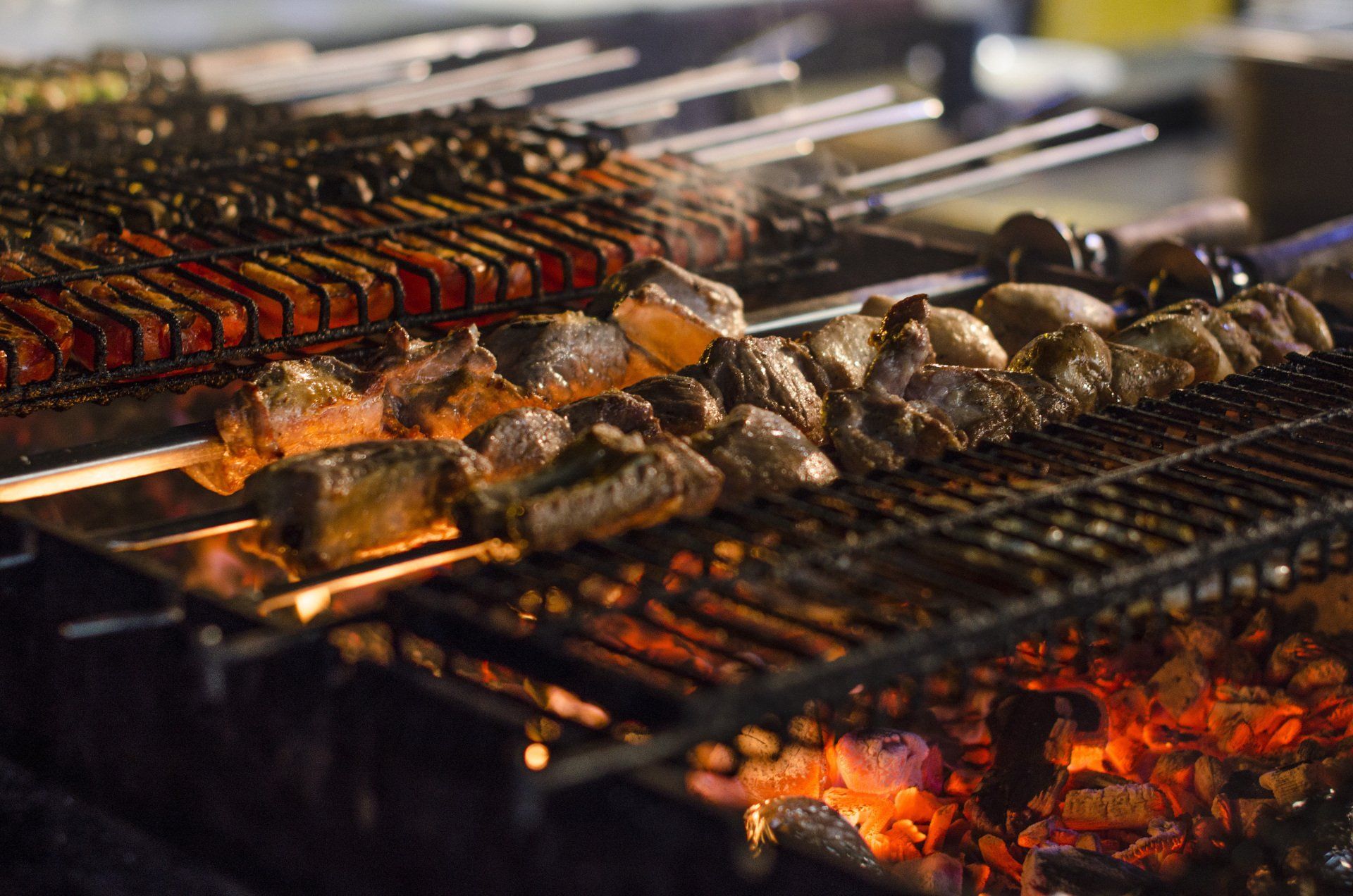 Mehrere Spieße mit Fleisch garen auf einem Grill