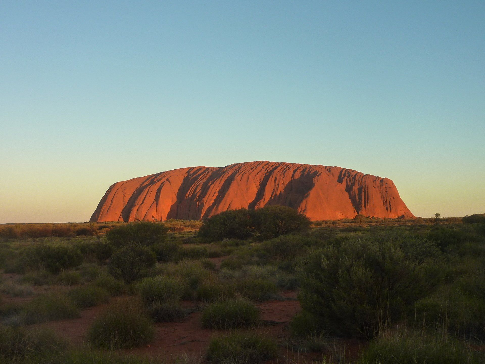 A large rock formation in the middle of a desert.