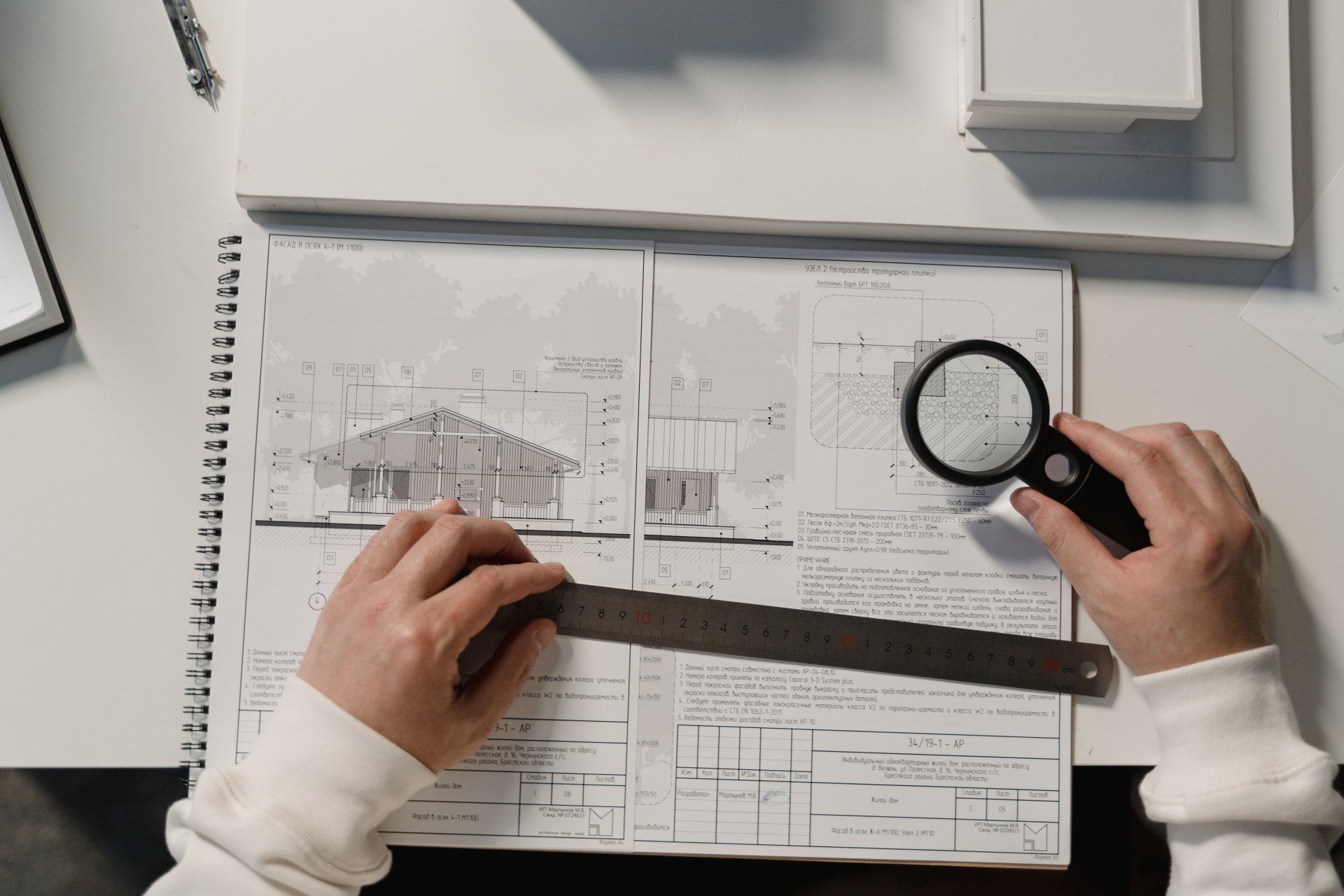 A person is using a magnifying glass to look at a drawing.