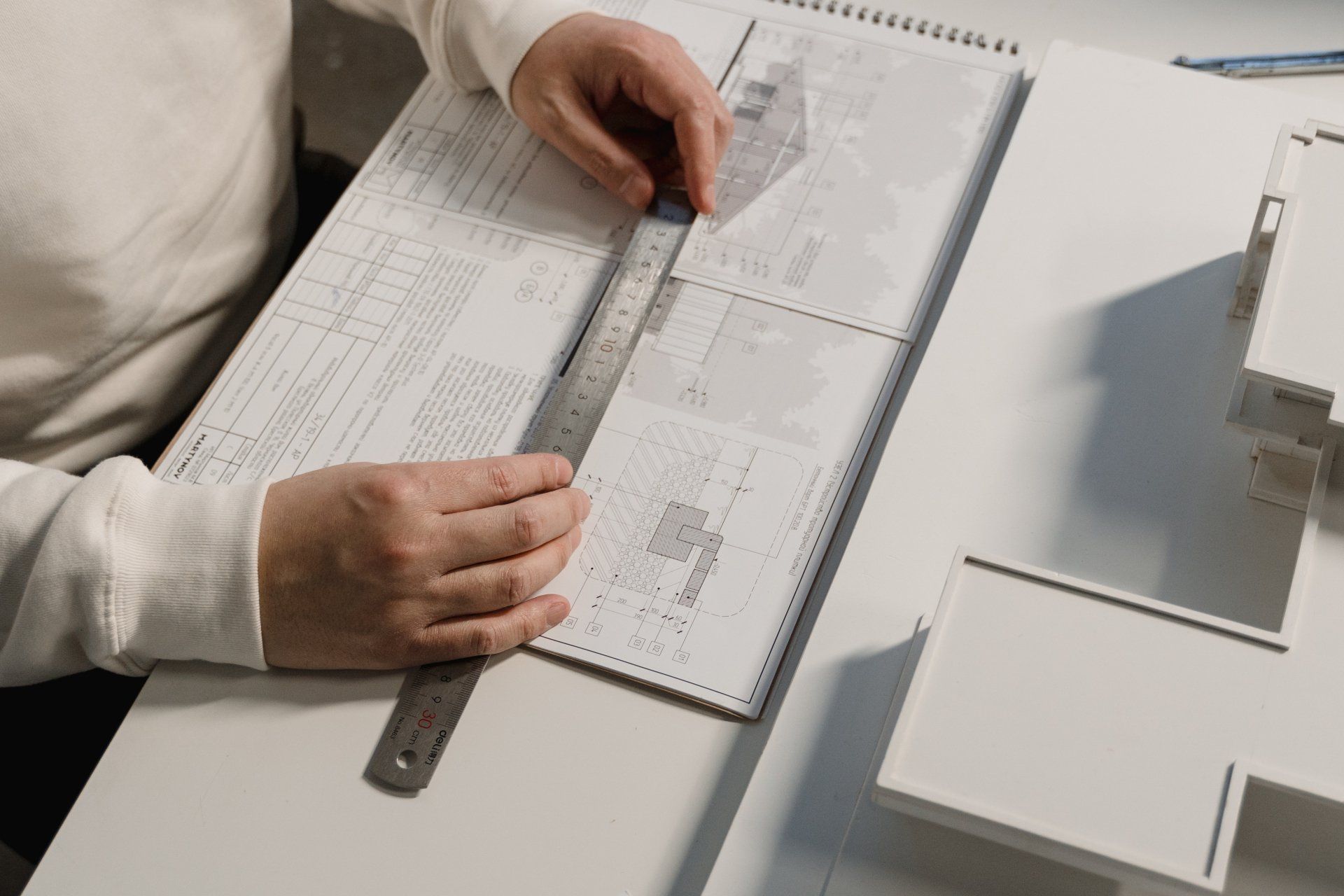 A person is using a ruler to measure a piece of paper.