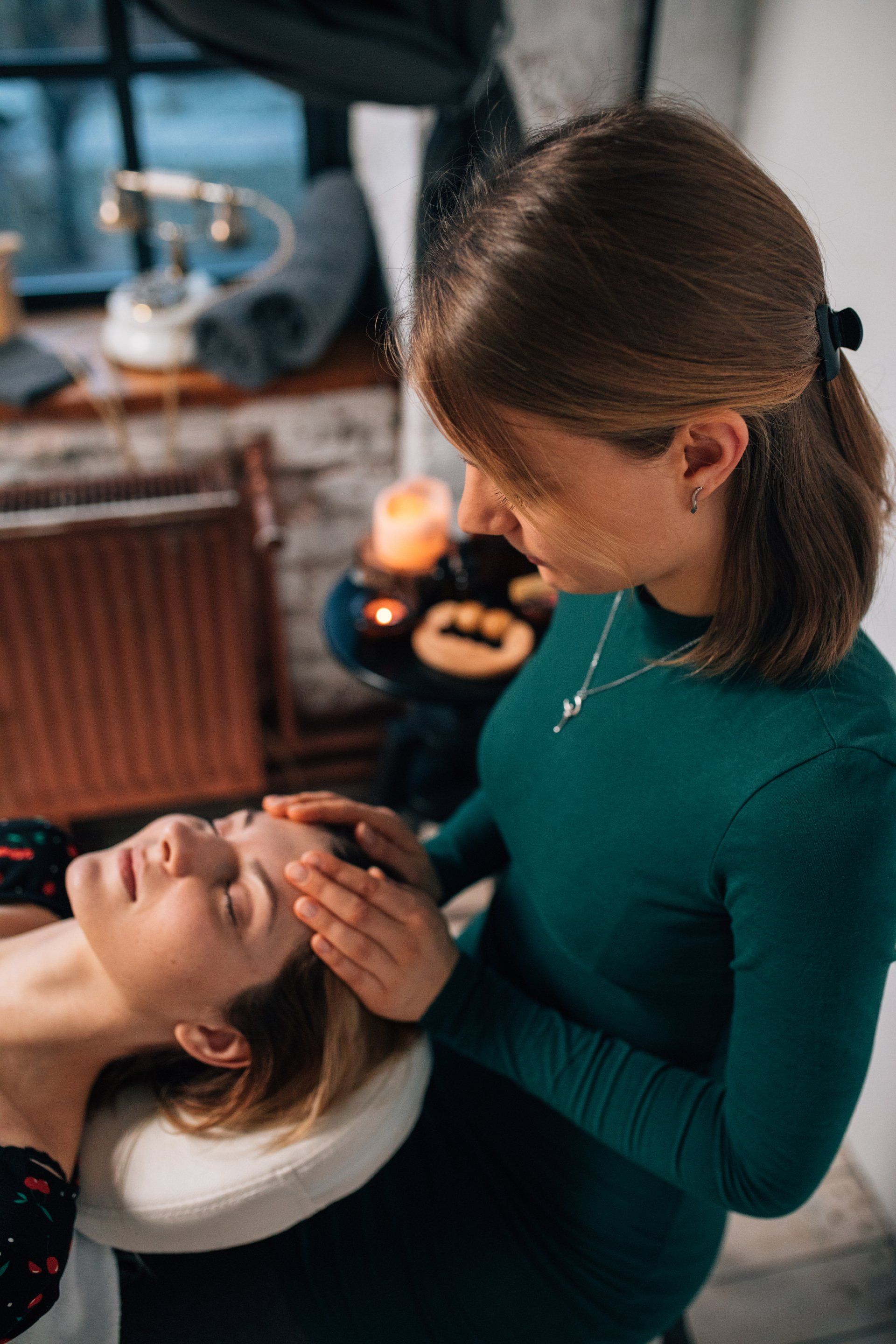 A woman is giving a woman a head massage in a spa.