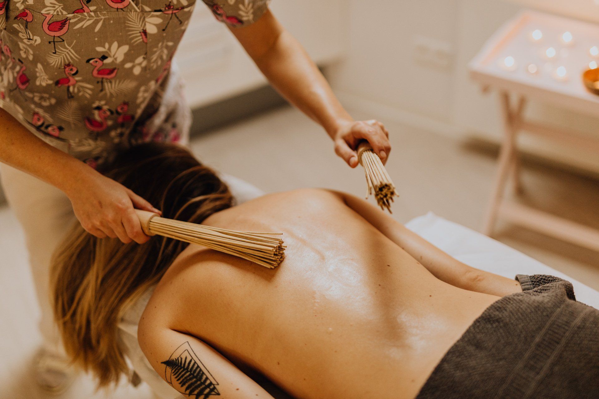 client on massage table receiving bamboossage on back
