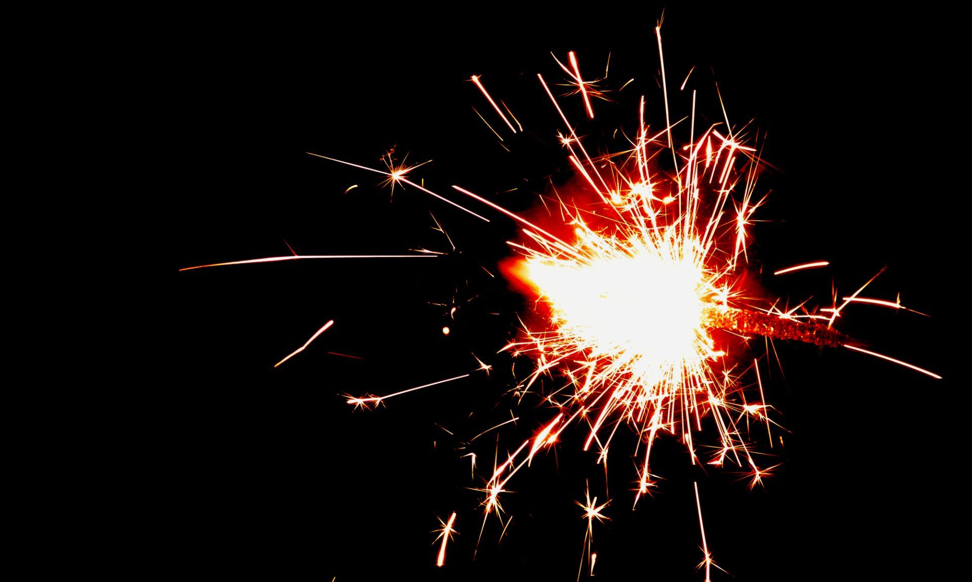 A close up of a sparkler on a black background