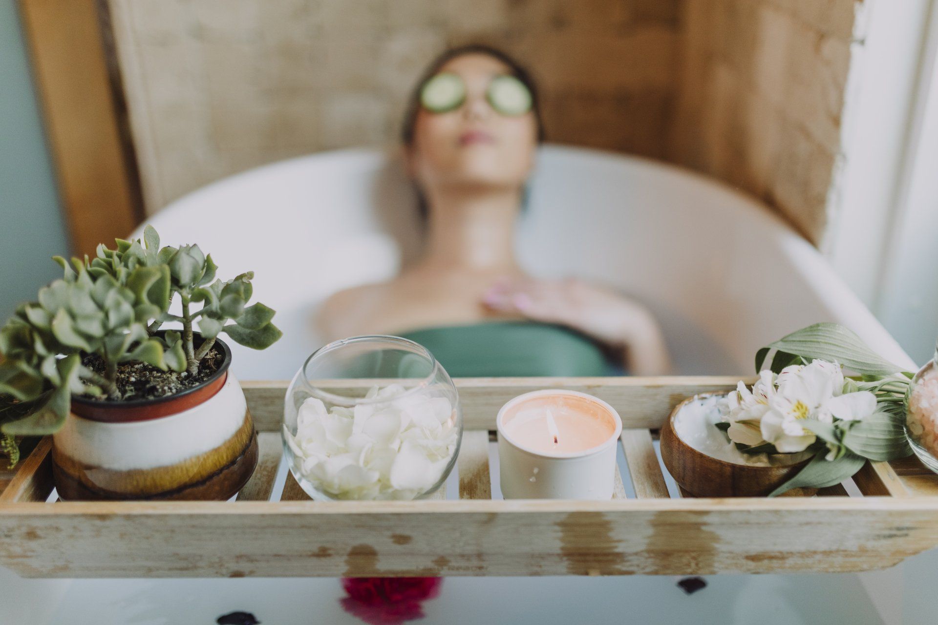 a woman is taking a bath with cucumber slices on her eyes .
