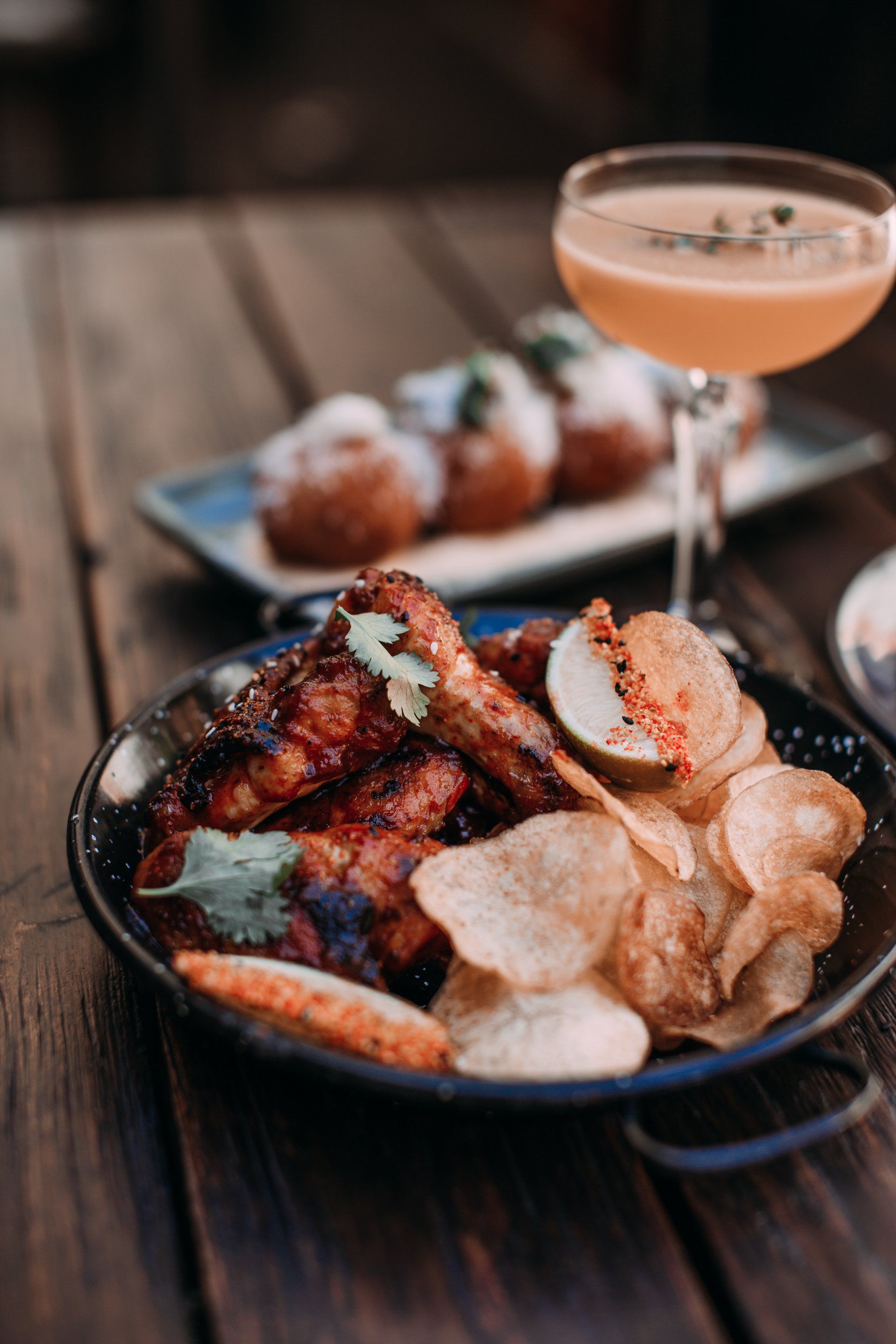 A plate of food and a glass of wine on a wooden table.
