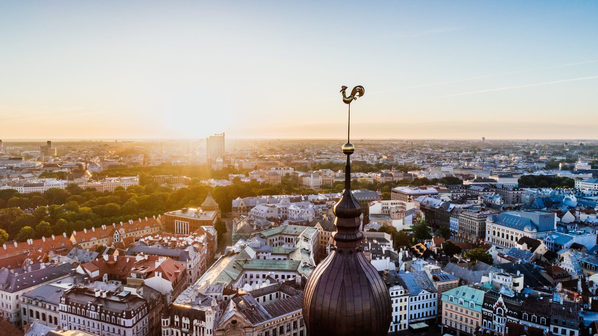 An aerial view of a city with a weather vane on top of a building.