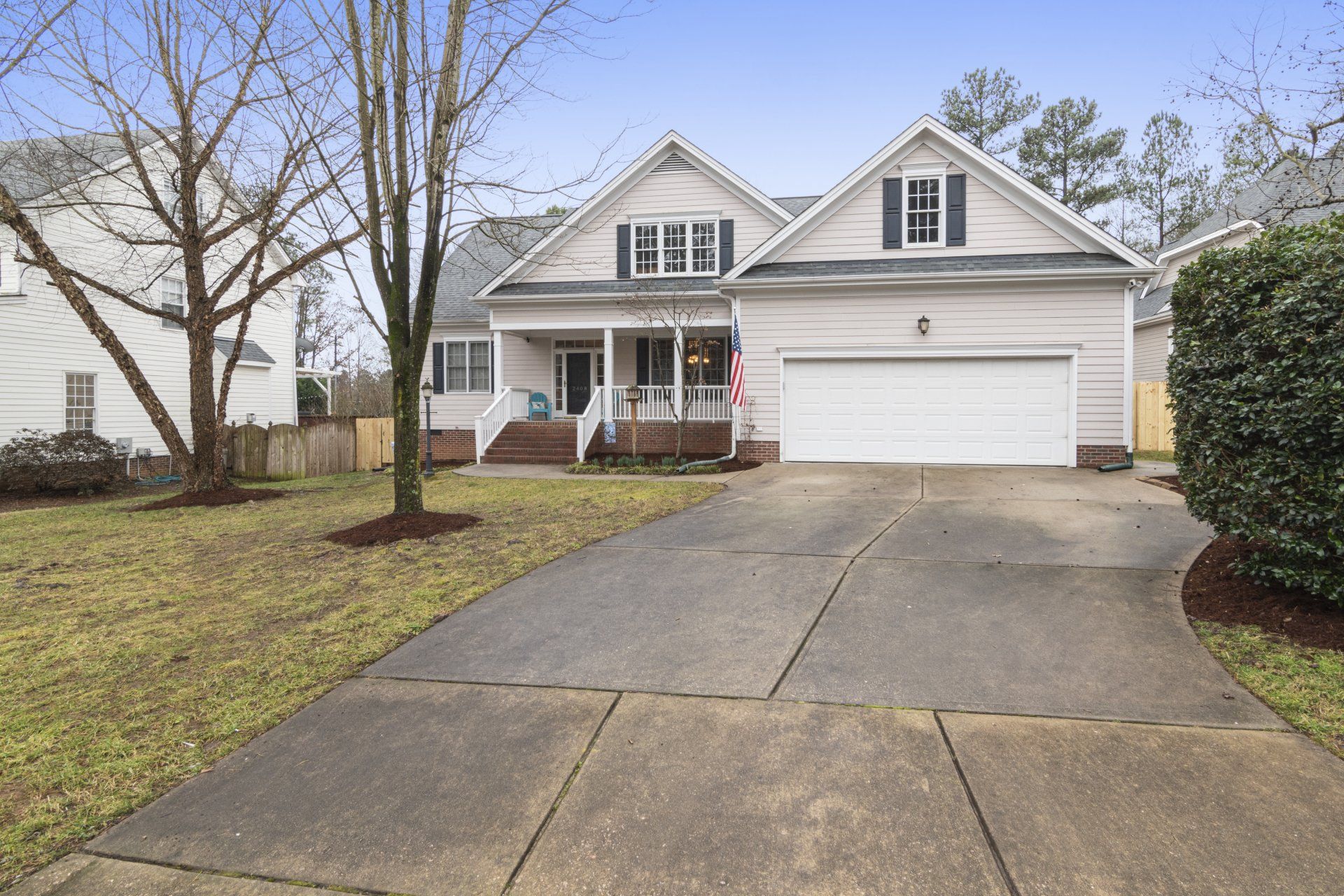 A white house with a white garage door is for sale.
