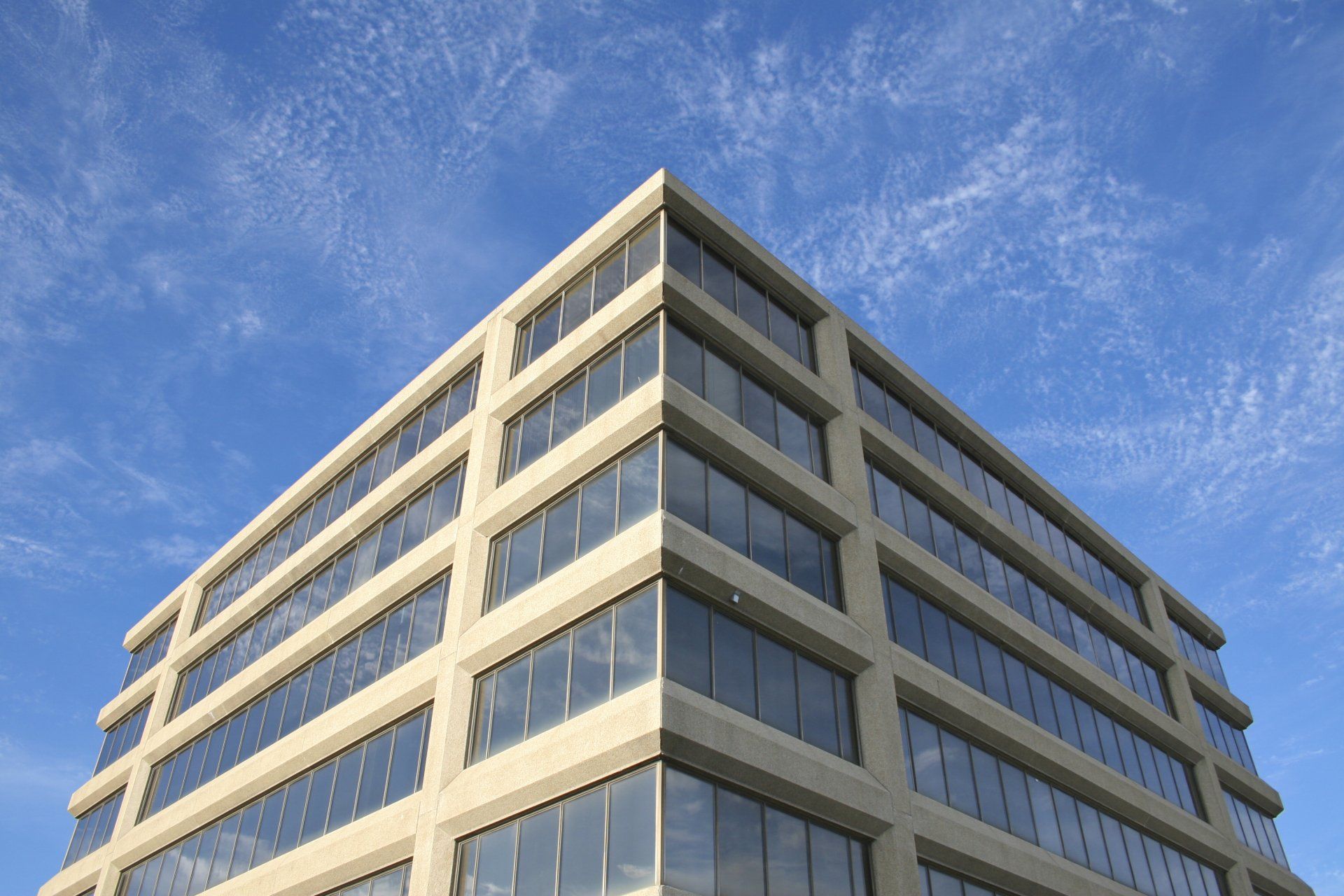 Mid-rise office building against a blue sky