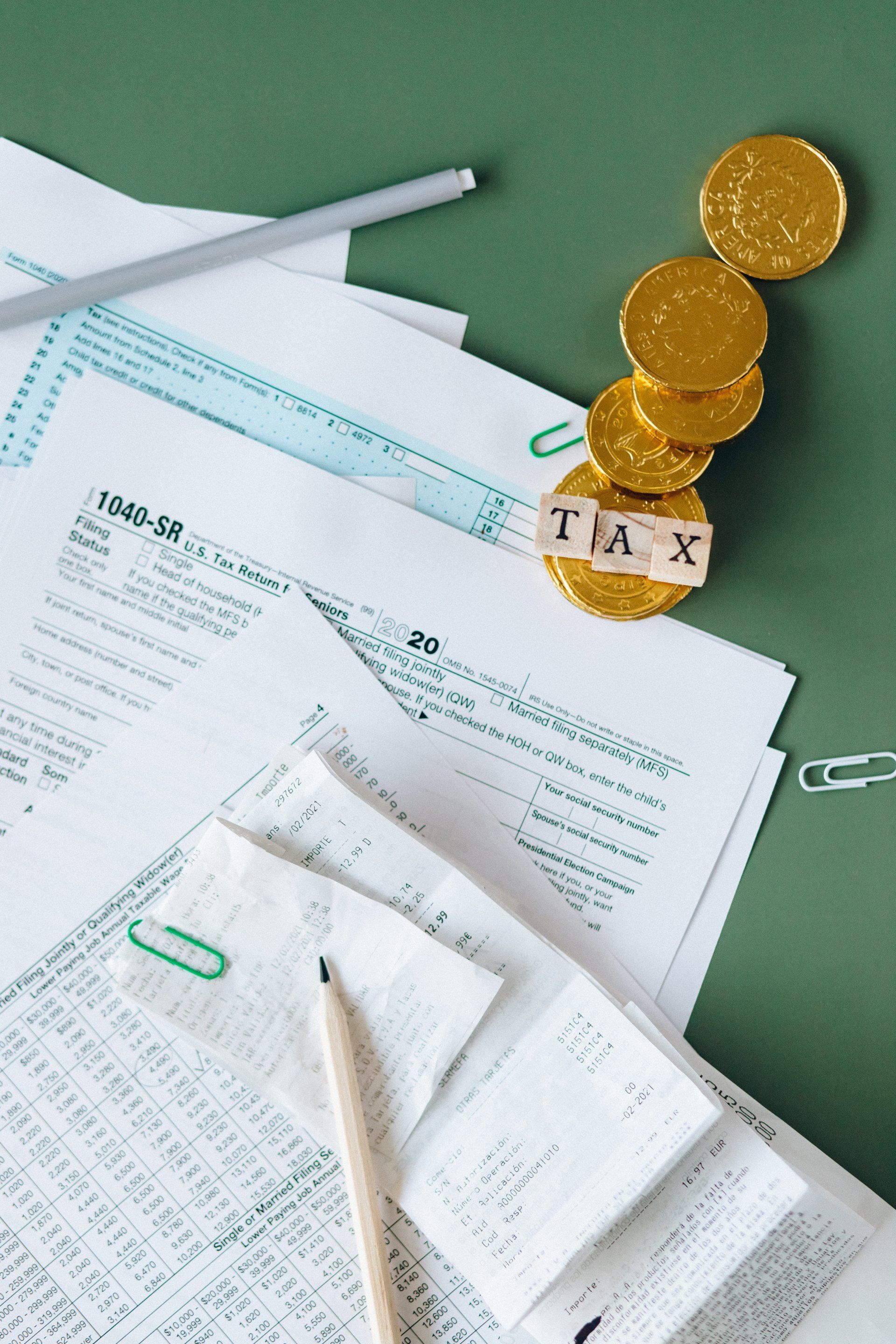 A stack of gold coins is sitting on top of a pile of papers.