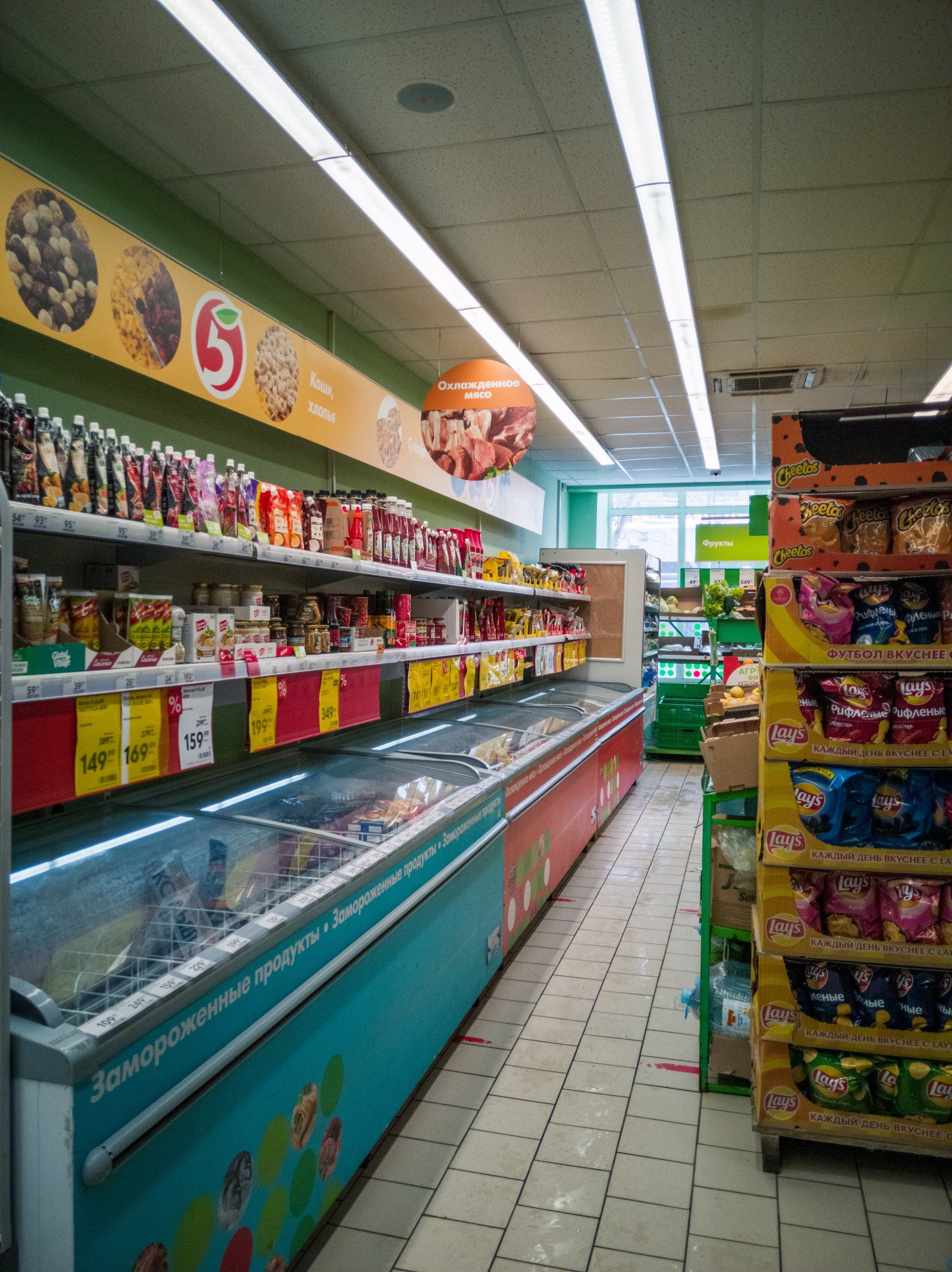 the inside of a supermarket with a lot of shelves and ice cream freezers .