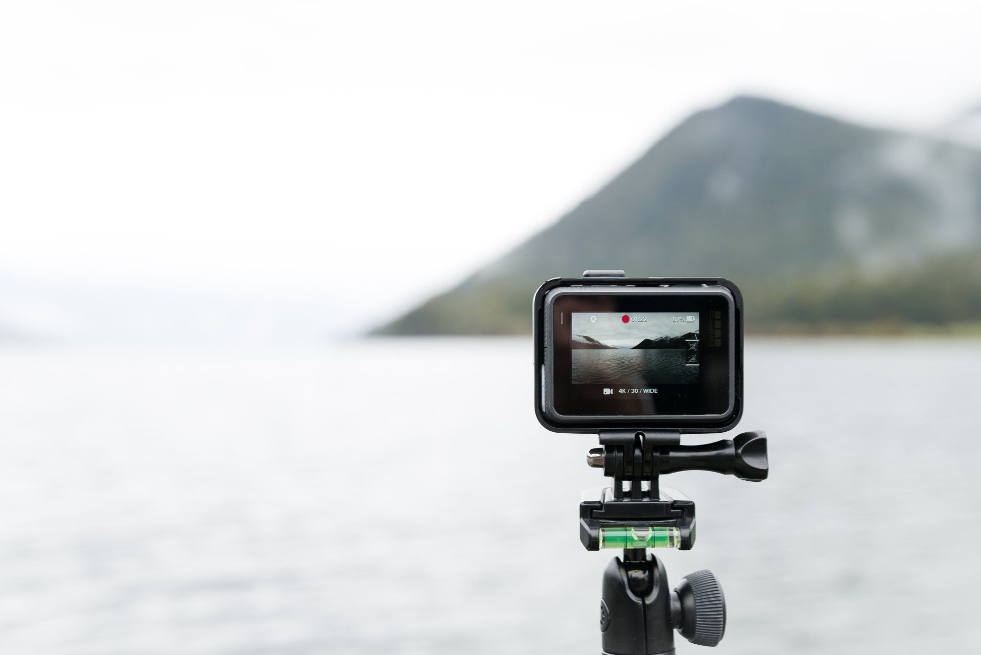 a camera on a tripod is taking a picture of a lake .