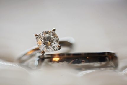A close up of a diamond ring and a wedding band.
