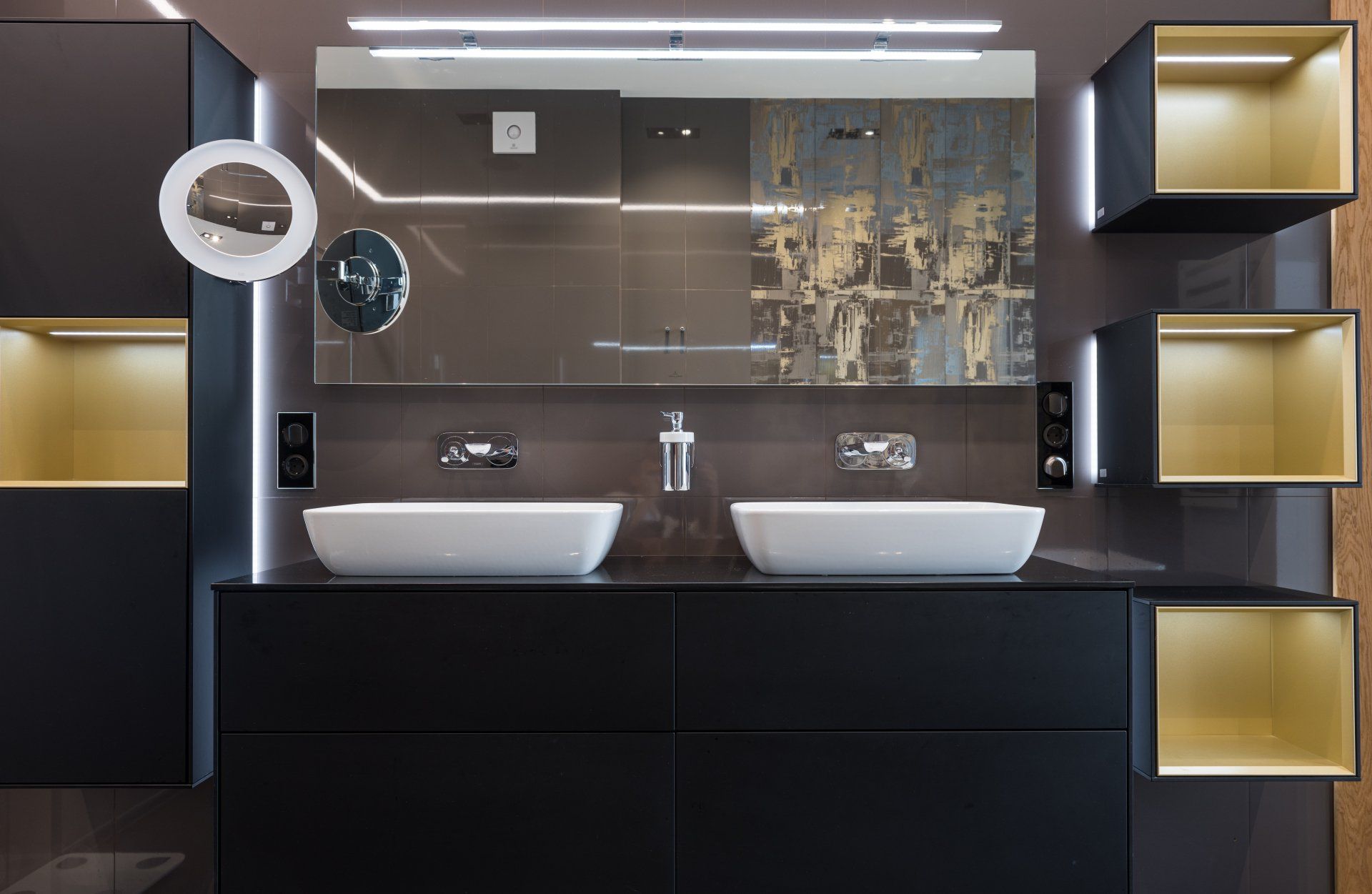 Modern double-sink bathroom vanity with black cabinetry, mirrors, and gold accent shelving