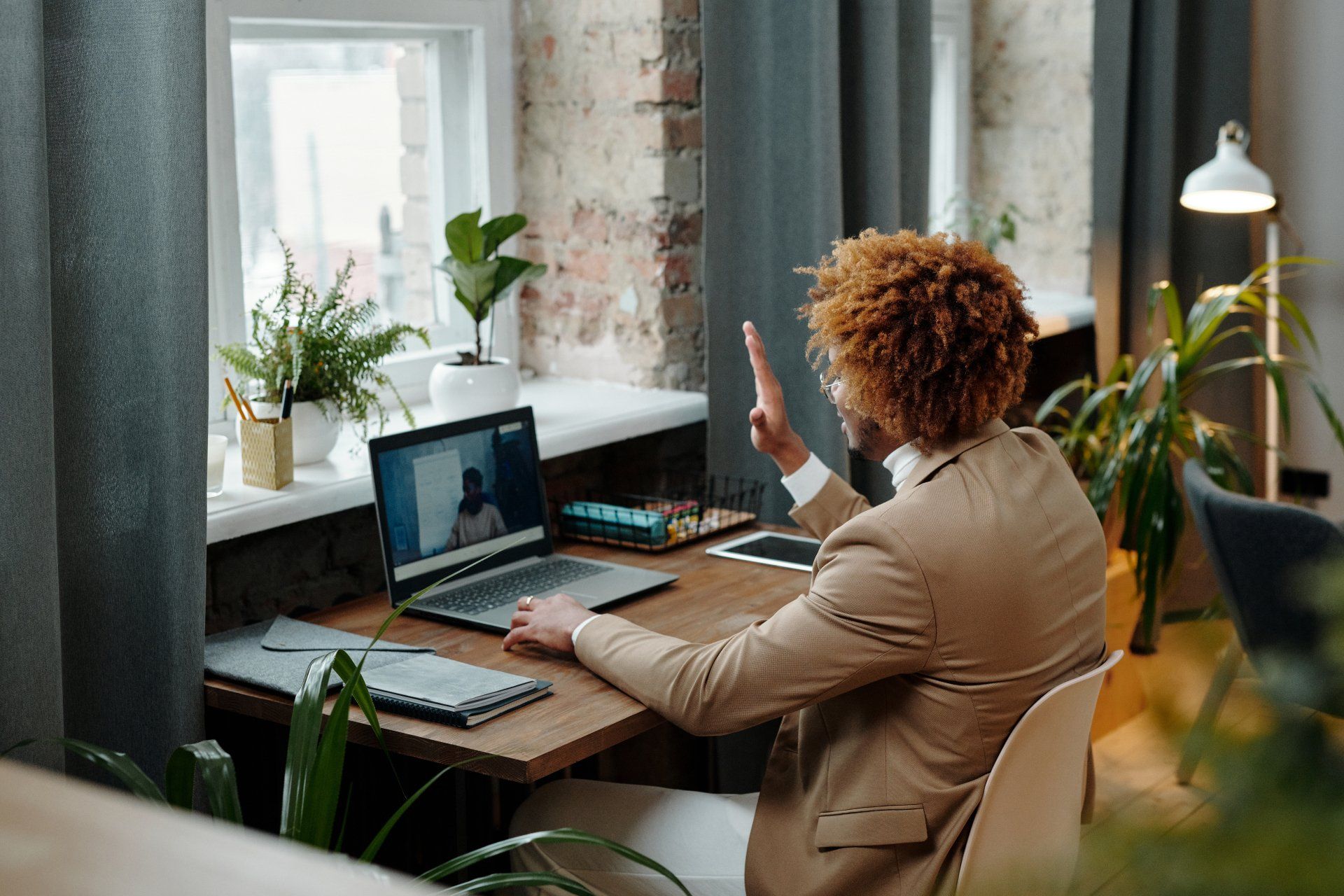 A man is sitting at a desk using a laptop computer.