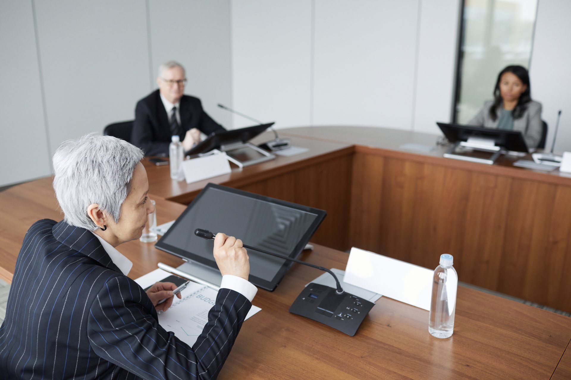 A group of people are sitting at a table in a court room.