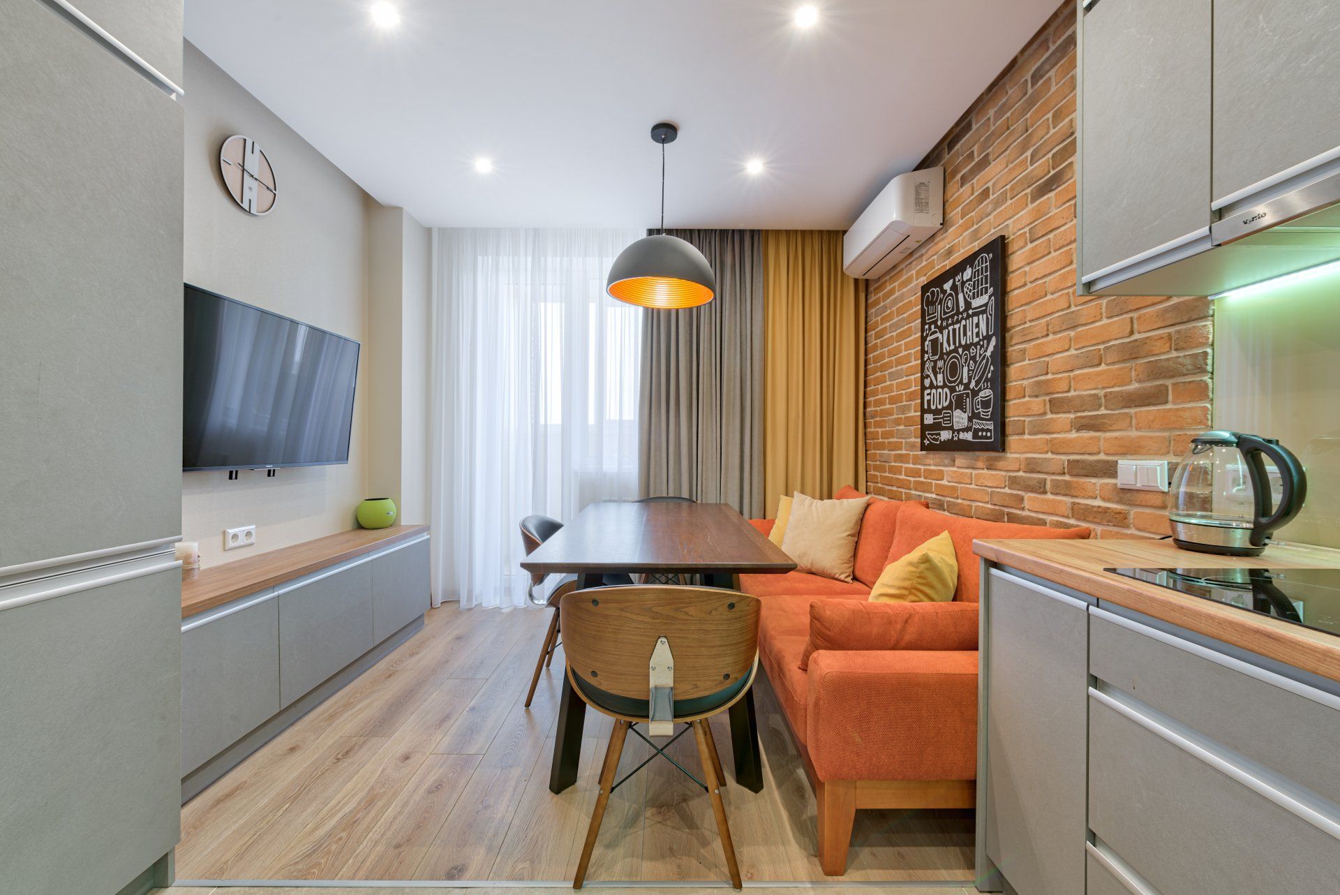 A living room with a couch , table , chairs and a television.